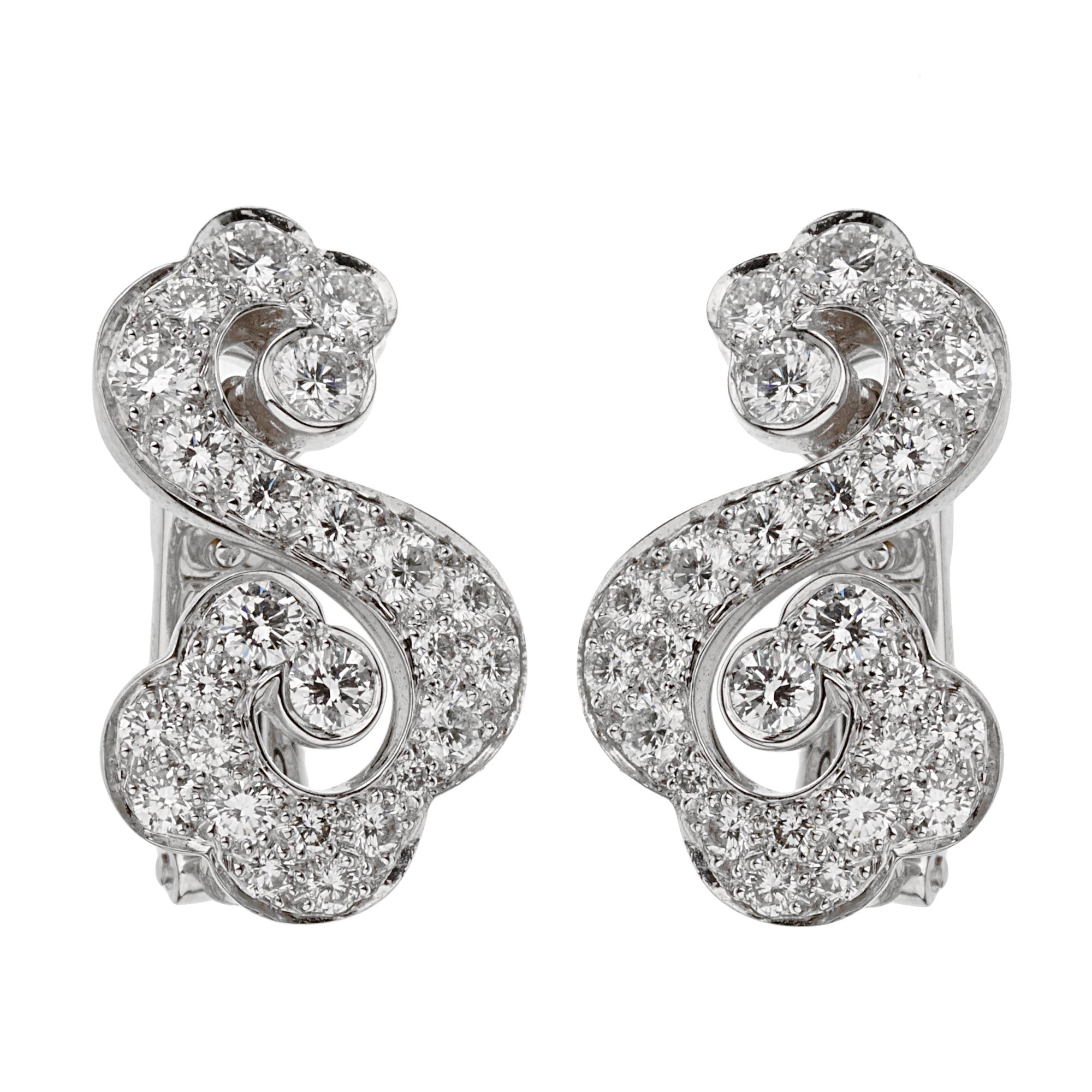 A magnificent pair of Cartier diamond earrings showcasing an openwork scrolling motif set in 18k white gold. The earrings boast 2.30ct of the finest original Cartier round brilliant cut diamonds.