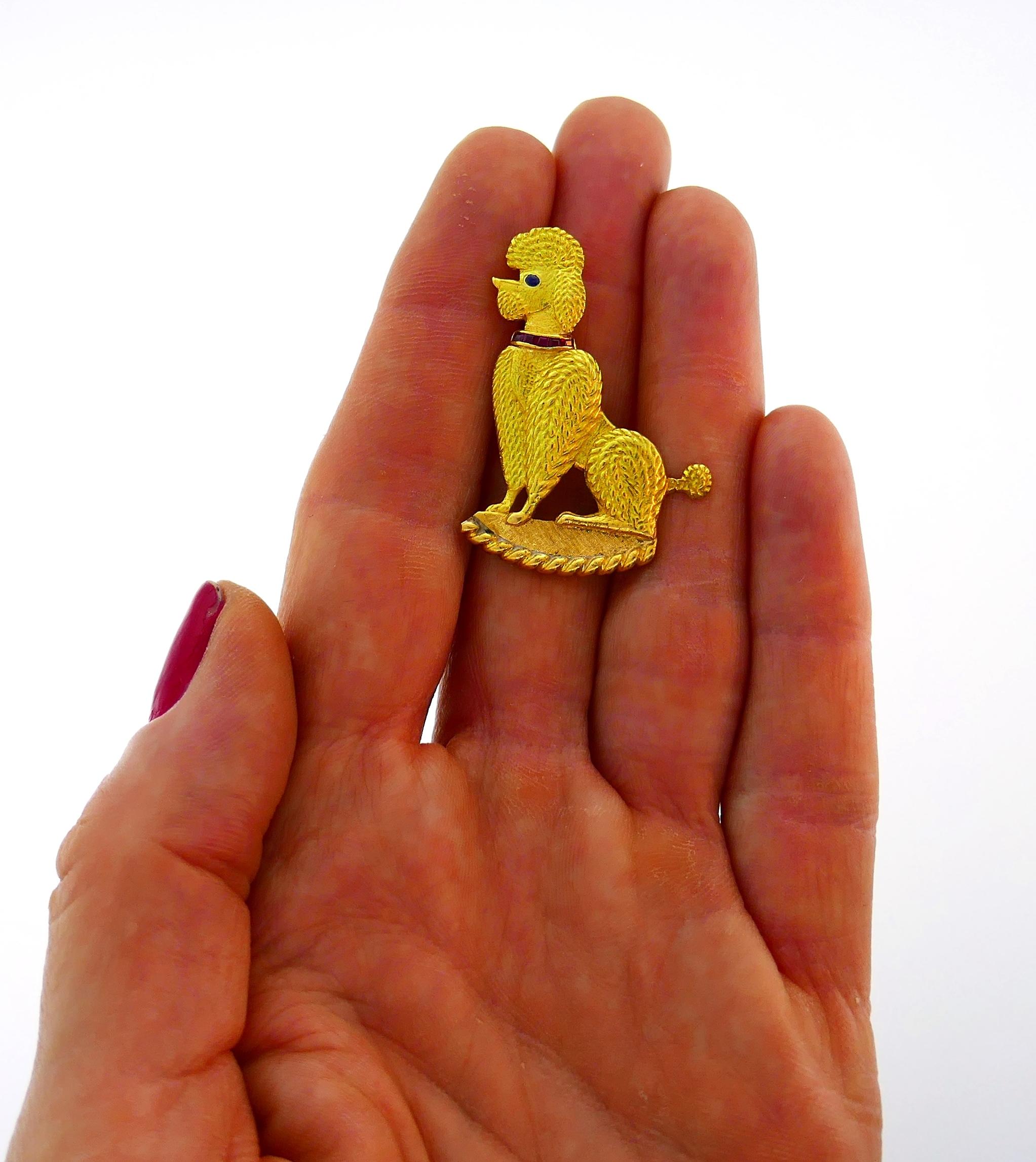 An iconic poodle pin created by Cartier in the 1950s. Cute and joyful, the pin is a great addition to your jewelry collection.
The pin is made of 18 karat (stamped) yellow gold, the poodle's collar is encrusted with pre-cut rubies and its eye is