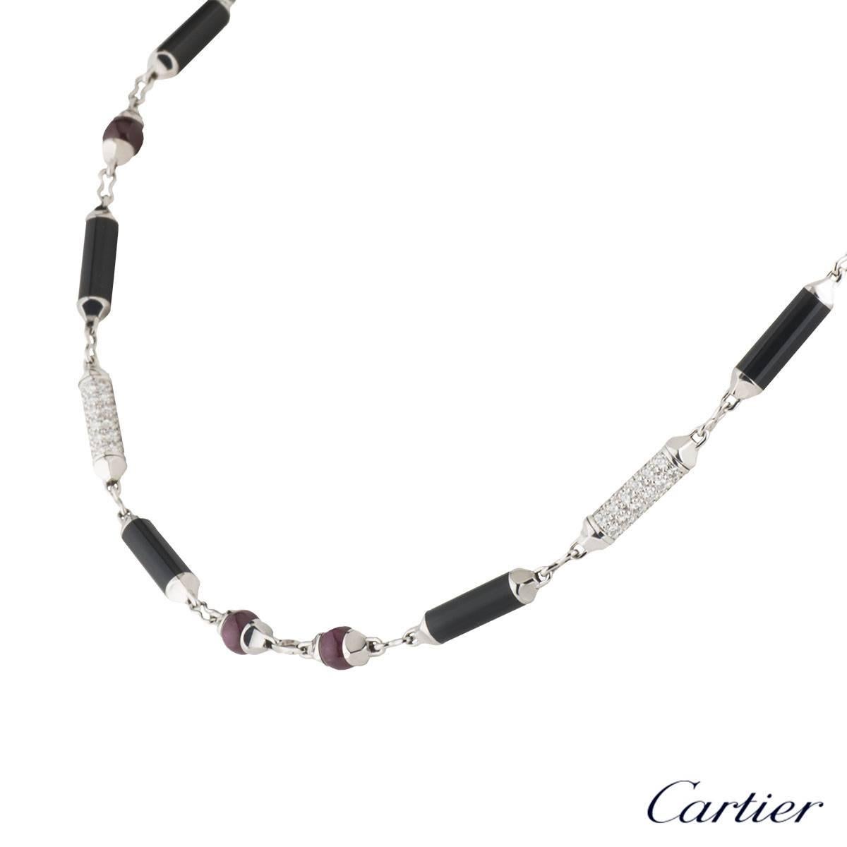 A unique 18k white gold diamond ruby and onyx Cartier necklace from the Le Baiser Du Dragon collection. The bracelet comprises of 15 cylinder bar motifs, 11 with an onyx inlay and 4 with 168 round brilliant cut diamonds. The diamonds have a total