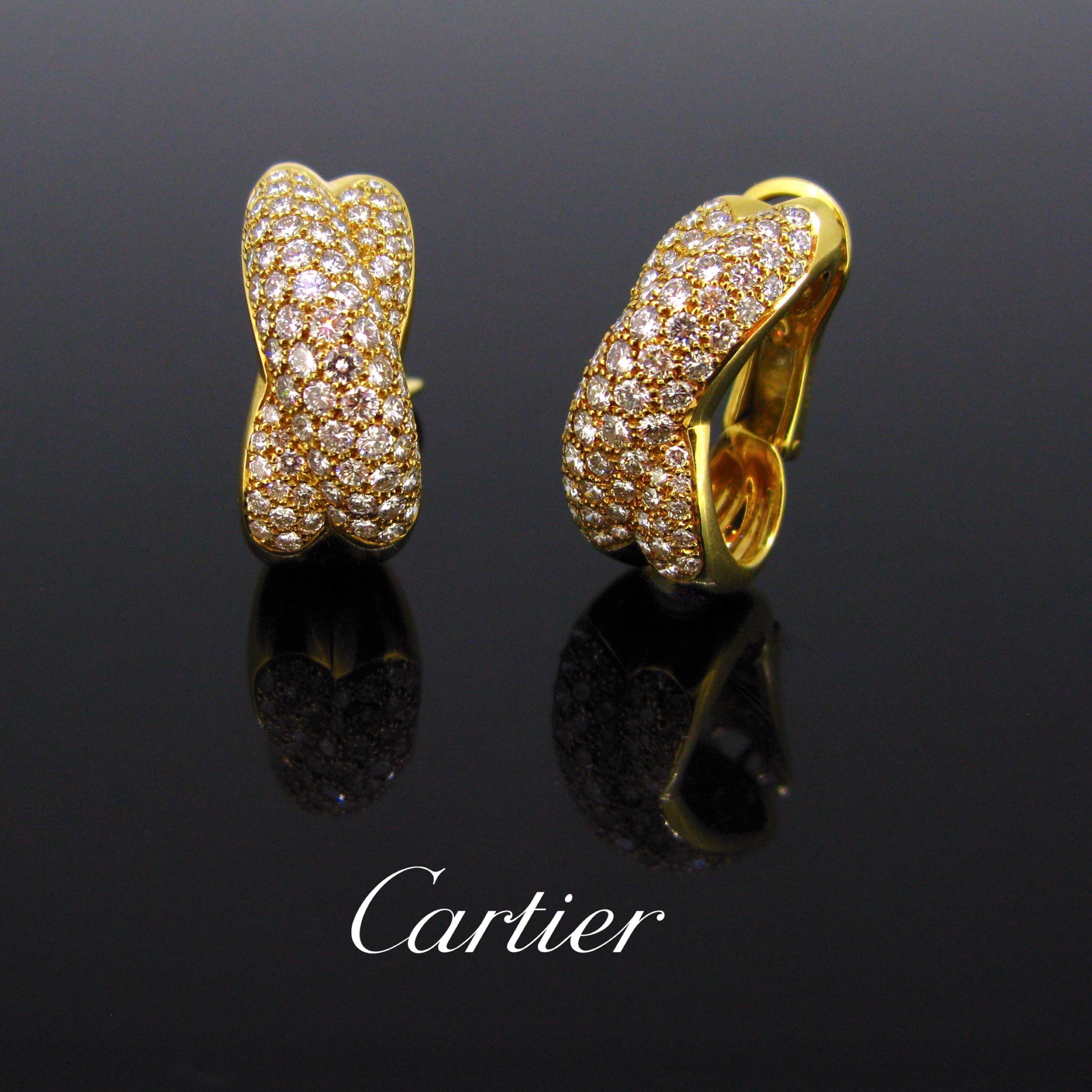 These Cartier earrings are fully made in 18kt yellow gold. Each features 85 lively and sparkly brilliant cut diamonds. It is signed and numbered on the rim and on the back. The earrings come with their original box. The total diamond carat weight is