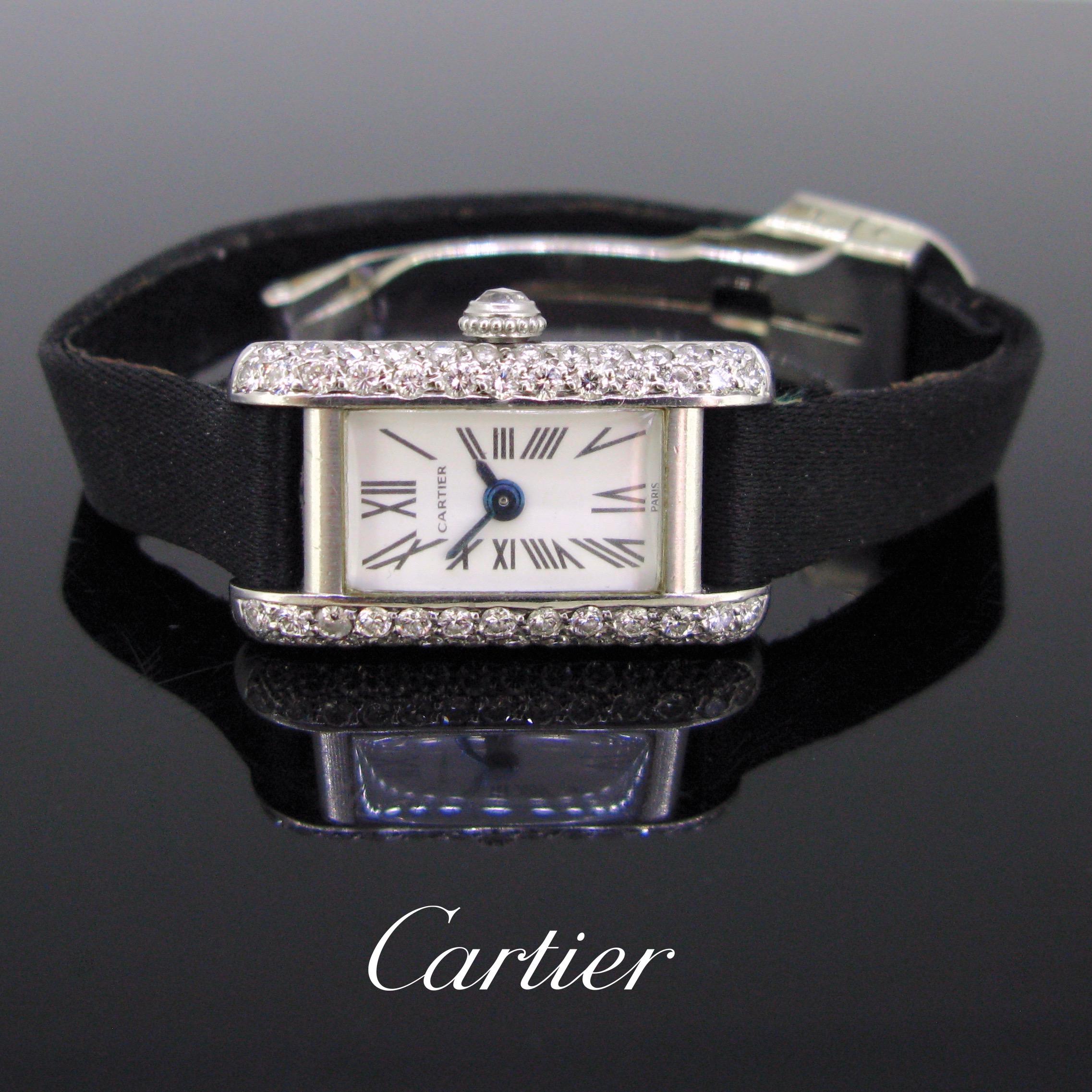 This wristwatch comes from the Sixties. The case is fully made in platinum and adorned with round cut diamonds. It is the Tank Model. The Tank line was created by Louis Cartier in 1917. The button is adorned with a rose cut diamond. The deployment