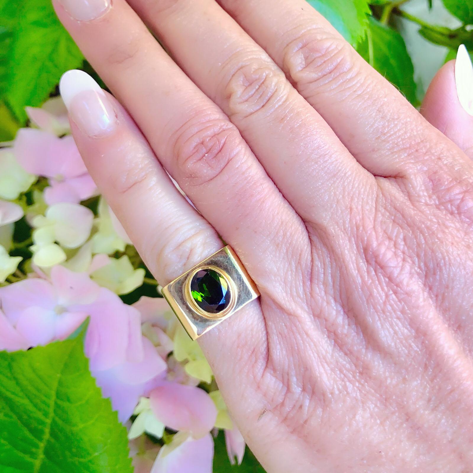 Cartier Dinh Van ring in 18k yellow gold square setting with an oval mixed cut green tourmaline.  The ring is a size 5 3/4.  A modern unconventional ring designed by French Vietnamese jeweller Jean Dinh Van.