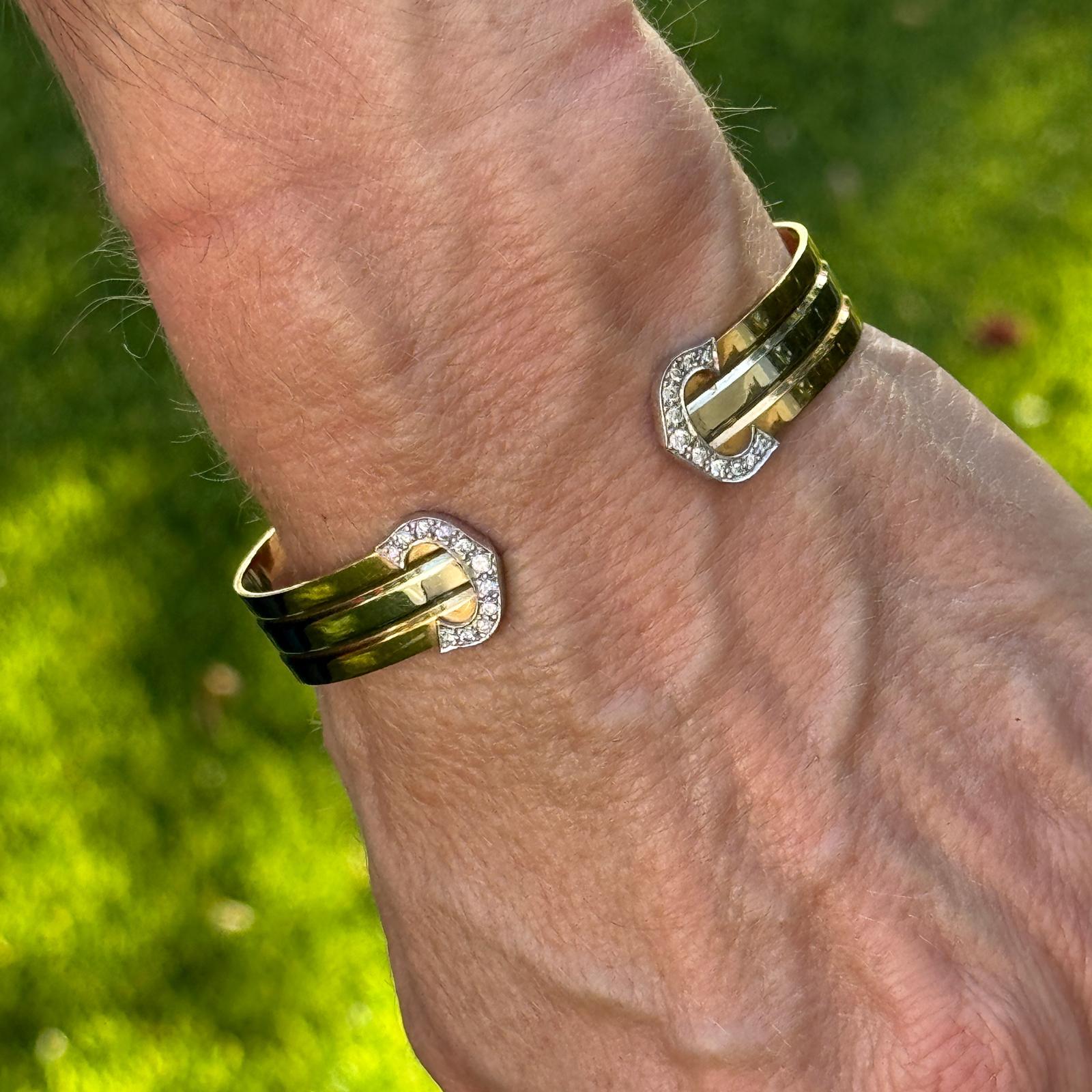Dieser exquisite Armreif von Cartier mit Doppel-C ist aus luxuriösem 18-karätigem Dreifarbgold gefertigt - Gelb-, Weiß- und Roségold - und fügt sich nahtlos in ein elegantes, offenes Design ein. Das kultige Doppel-C-Motiv ist elegant mit Diamanten
