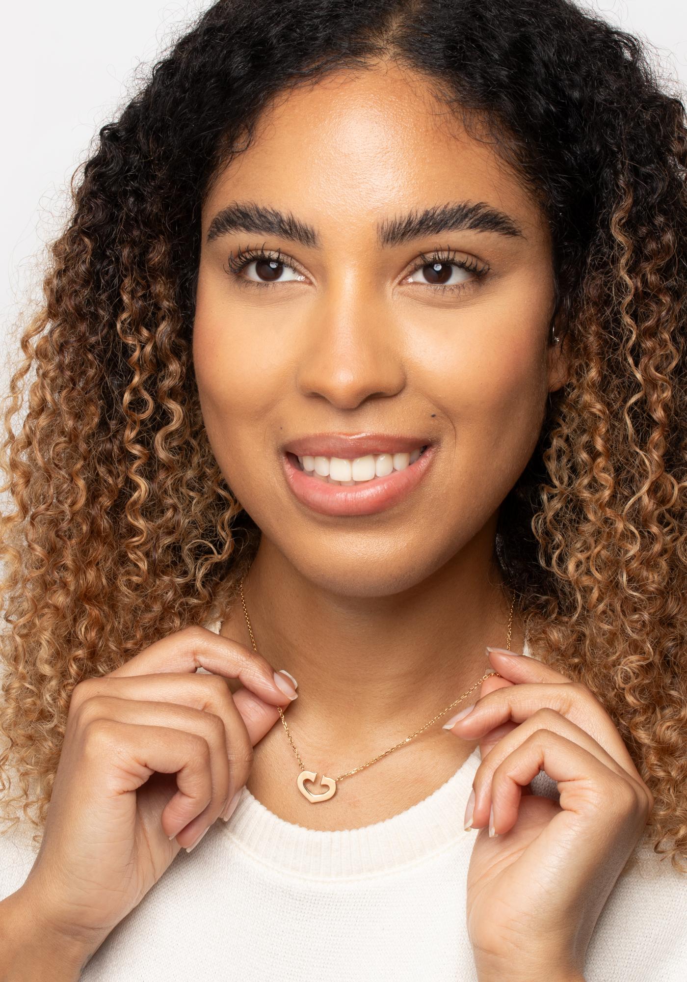 This beautiful vintage pendant comes from the makers at Cartier. The necklace features the iconic double C heart motif crafted in 18 carat yellow gold and held around the neck with a dainty trace chain and. The cartier makers marks can be found on