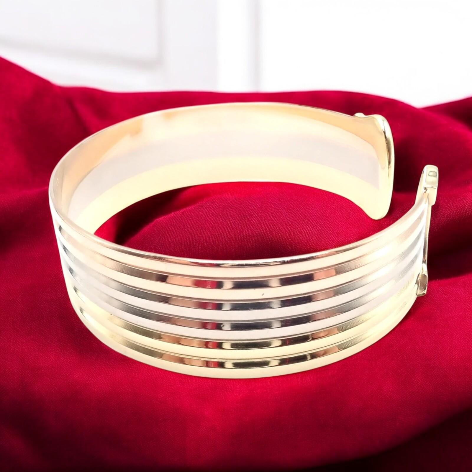 Pulsera brazalete doble C en oro tricolor de 18 quilates (amarillo, blanco y rosa) de Cartier. 
La pulsera brazalete ancha doble C de Cartier en oro tricolor de 18 quilates es una lujosa pieza que muestra la elegancia atemporal de Cartier.