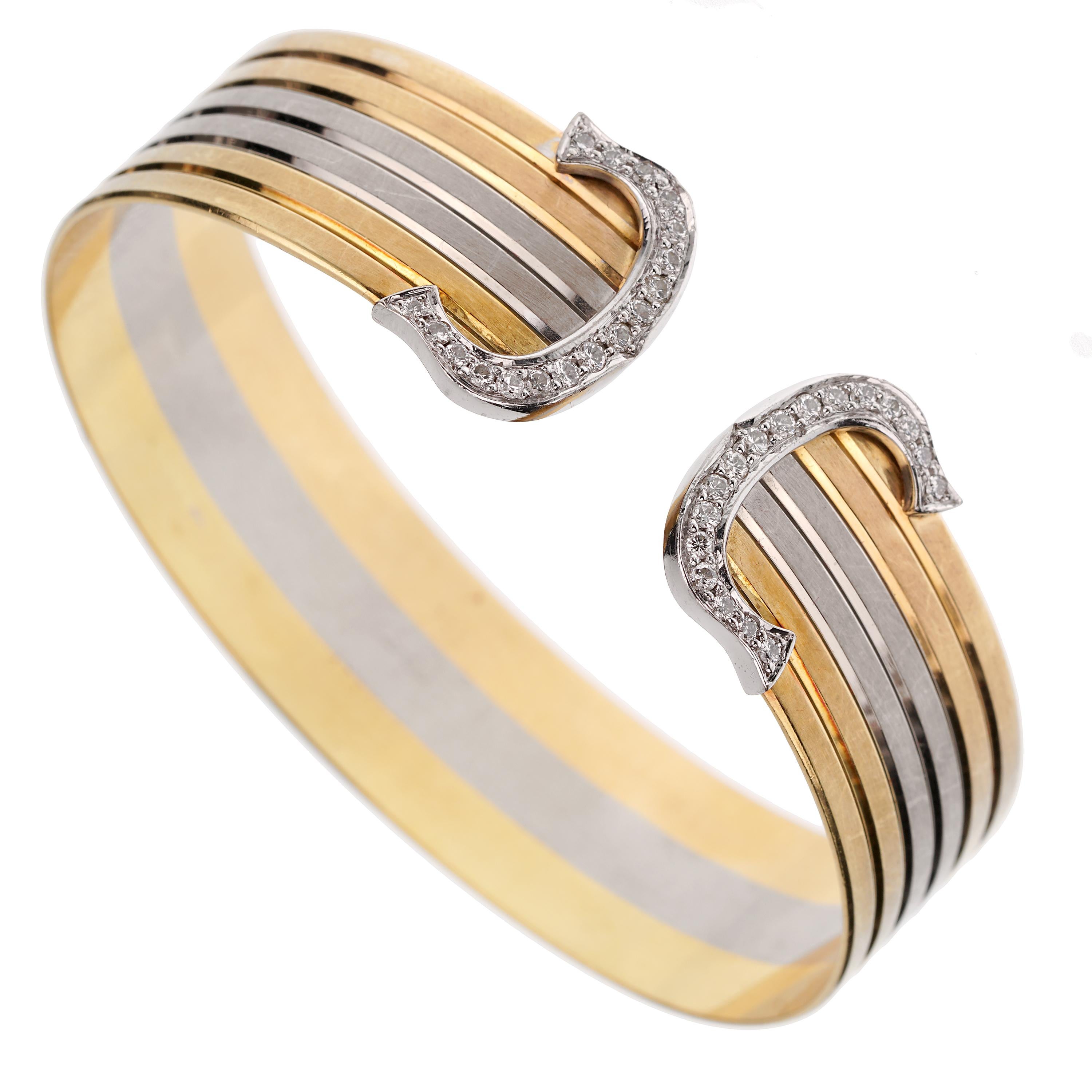 This Cartier Double C Vintage Diamond Cuff Tri-Color Bangle Bracelet embodies the quintessence of elegance and the celebrated craftsmanship of the renowned French jewelry maker, Cartier. A timeless piece from their collection, this bracelet is a