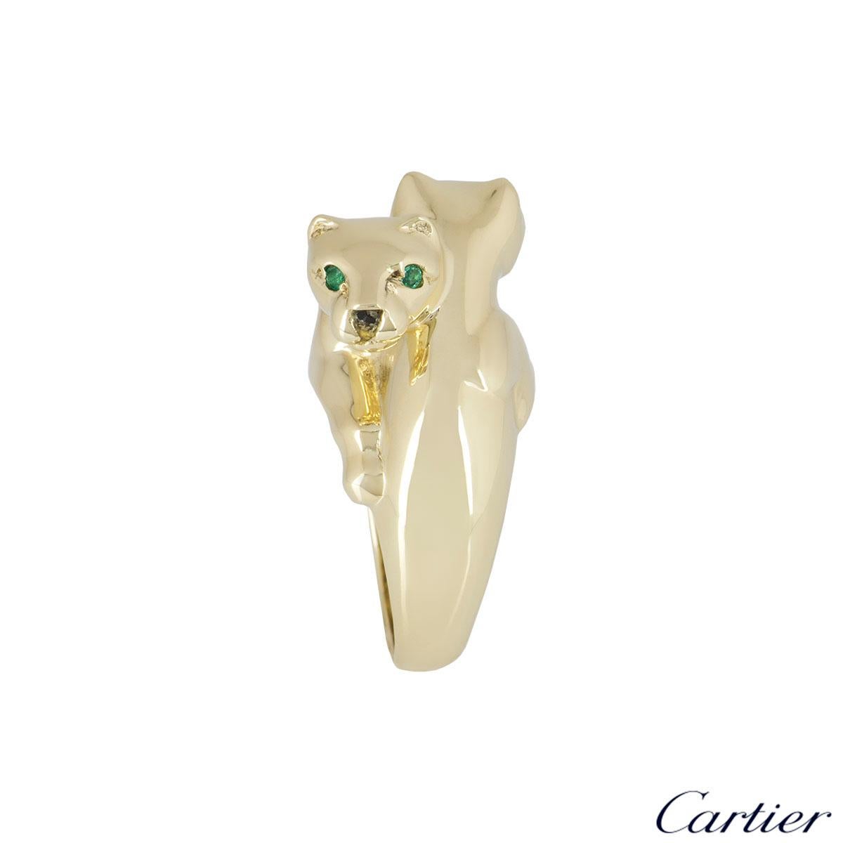 A beautiful 18k yellow gold ring by Cartier from the Panthere De Cartier collection. The ring is composed of two panthere head motifs beside each other and are complemented with two round emeralds set as the eyes and onyx for the nose with the body