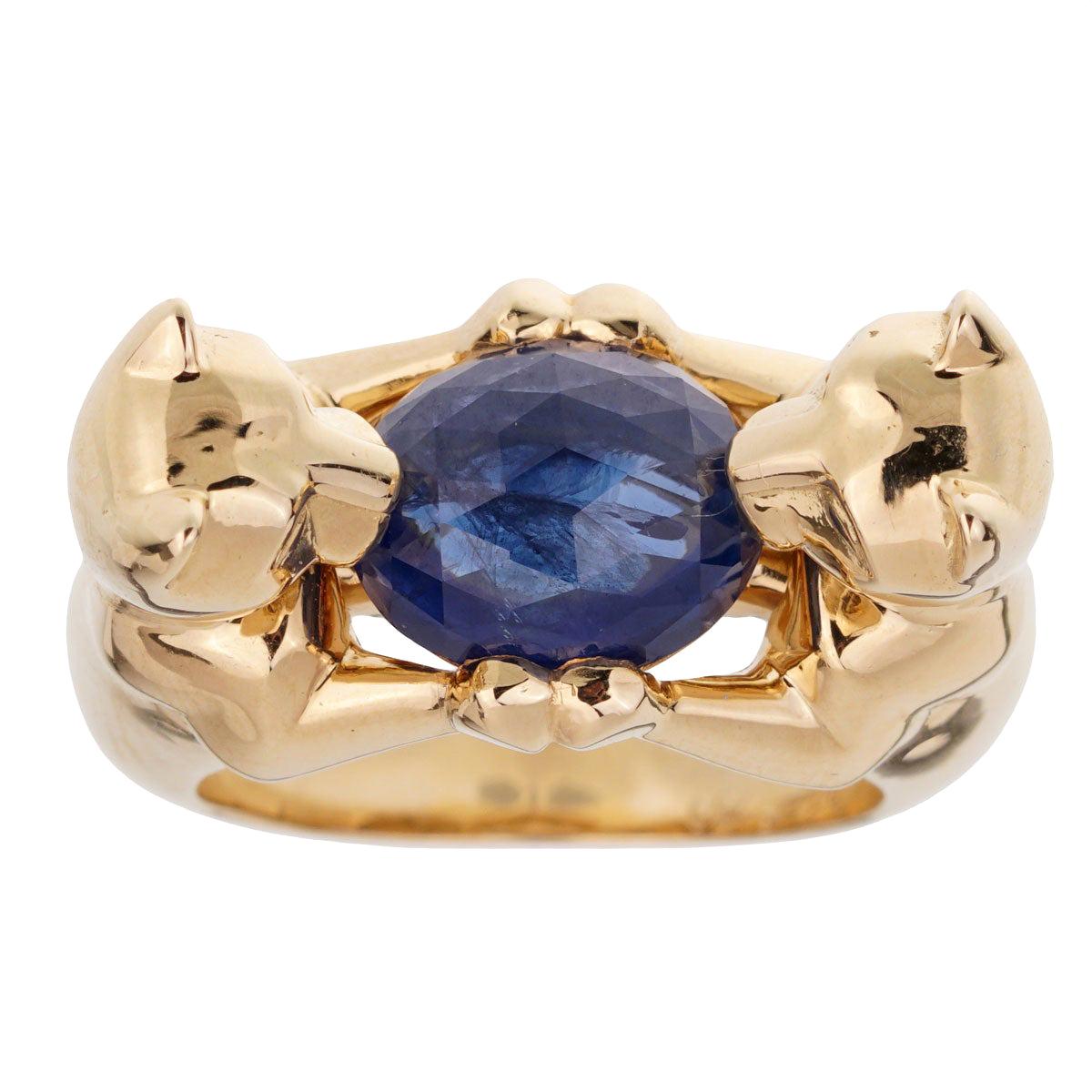 A magnificent Cartier ring featuring the iconic Panthere motifs crafted in 18k yellow gold holding a oval rose cut sapphire. The sapphire measures 10.11 x 8.87 x 5.50mm