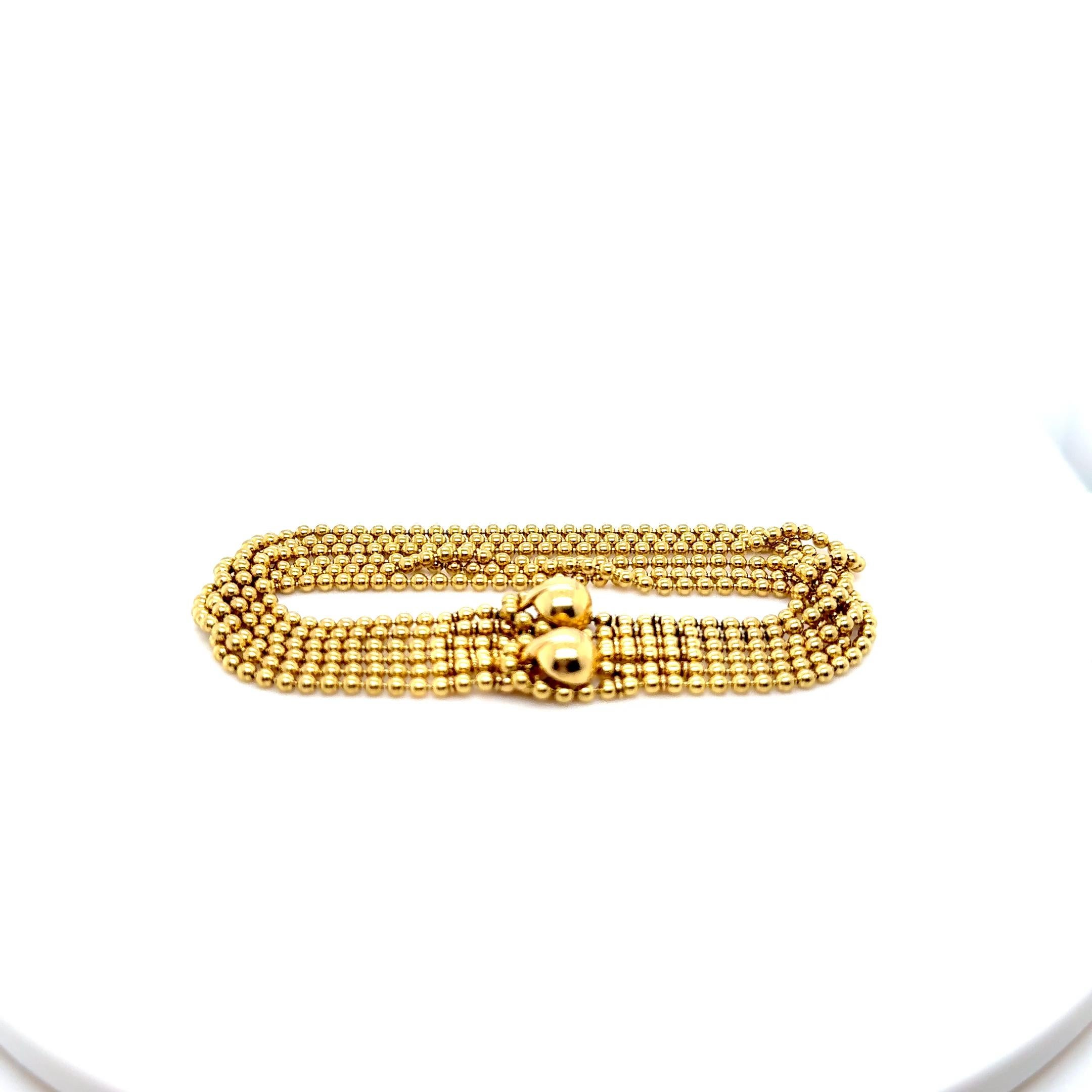 Este raro brazalete Cartier Draperie de Decollete de oro amarillo de 18 quilates con diseño de 6 vueltas que mide 7 pulgadas de largo y tiene un peso final de 29,6 gramos tiene el número de serie LO1884 del año de producción 1999 y muestra la
