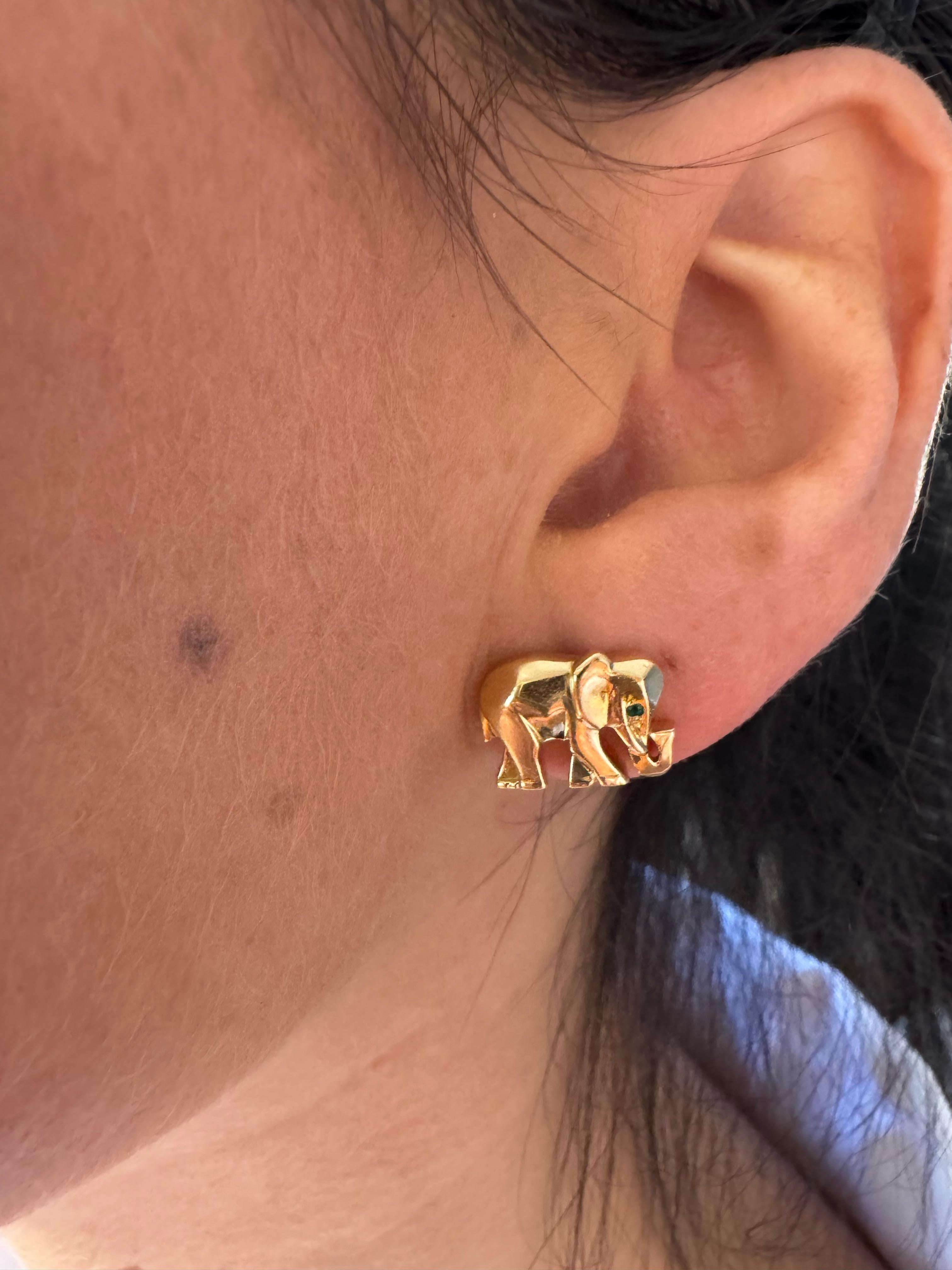 Rare Boucles d'oreilles éléphant de Cartier en or jaune 18 carats et émeraude 

Cette élégante paire d'Eleg de Cartier représente deux éléphants qui marchent, réalisés en or jaune 18 carats. Les yeux de chaque éléphant sont ornés d'une émeraude