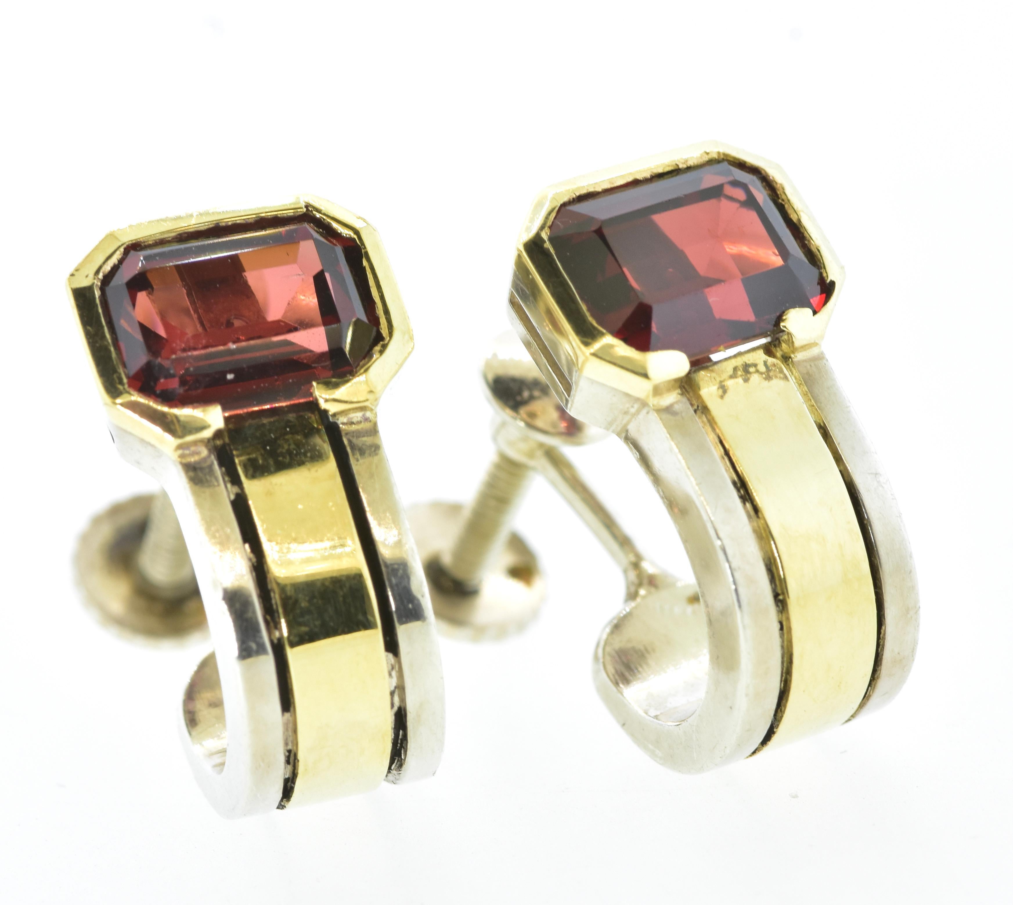 Cartier earrings in 18K yellow gold and sterling silver with natural red/orange emerald cut garnets each slightly larger than 1 ct., with a total weight of 2.15 cts.  These half hoop earrings are circa 1979 and have the original screw backs. They