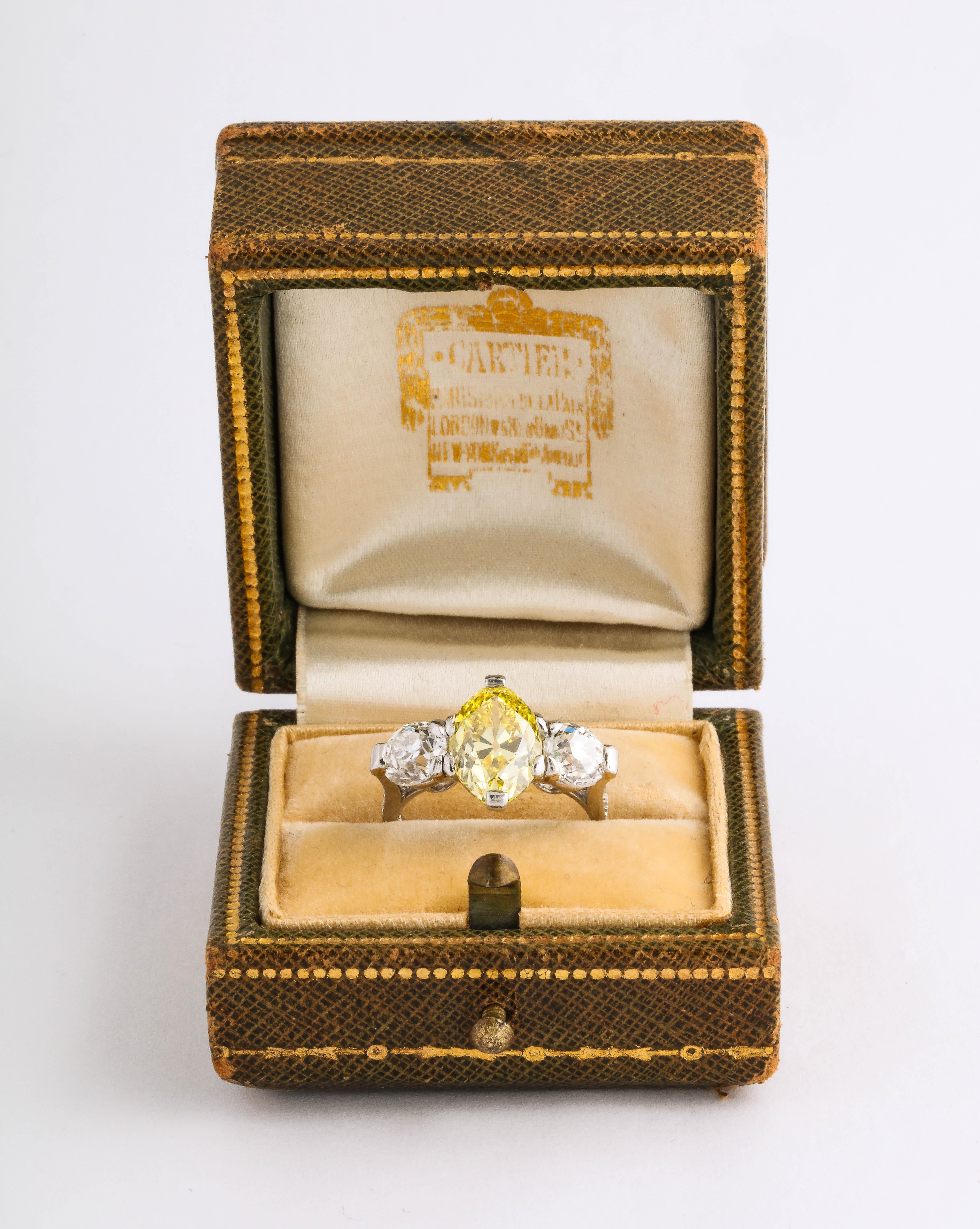 Cartier Edwardian Yellow and White Diamond Platinum Ring 

Materials:
Platinum 3.5 dwt

Stones:
Natural Fancy Vivid Yellow Diamonds VVS2
Marquise GIA report # 2195639958
2 old mine cut VVS1 E Color @ 1.70 cts tw

23 / 8837 no marked on inside of