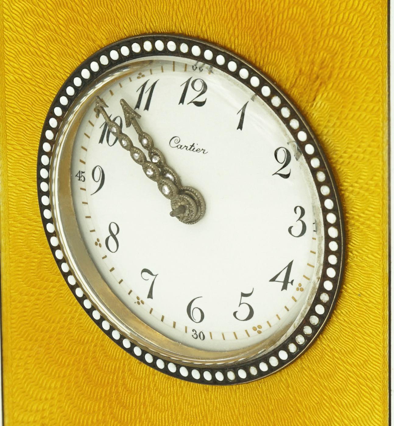 Cartier minute repeater clock, in yellow enamel, silver, agate and diamonds. 
Circa 1900-1905.

The dimensions are : hight 9,5 cm approximately include the button on the top.
Width 6,5 cm at the base
depth 5,5 cm at the base