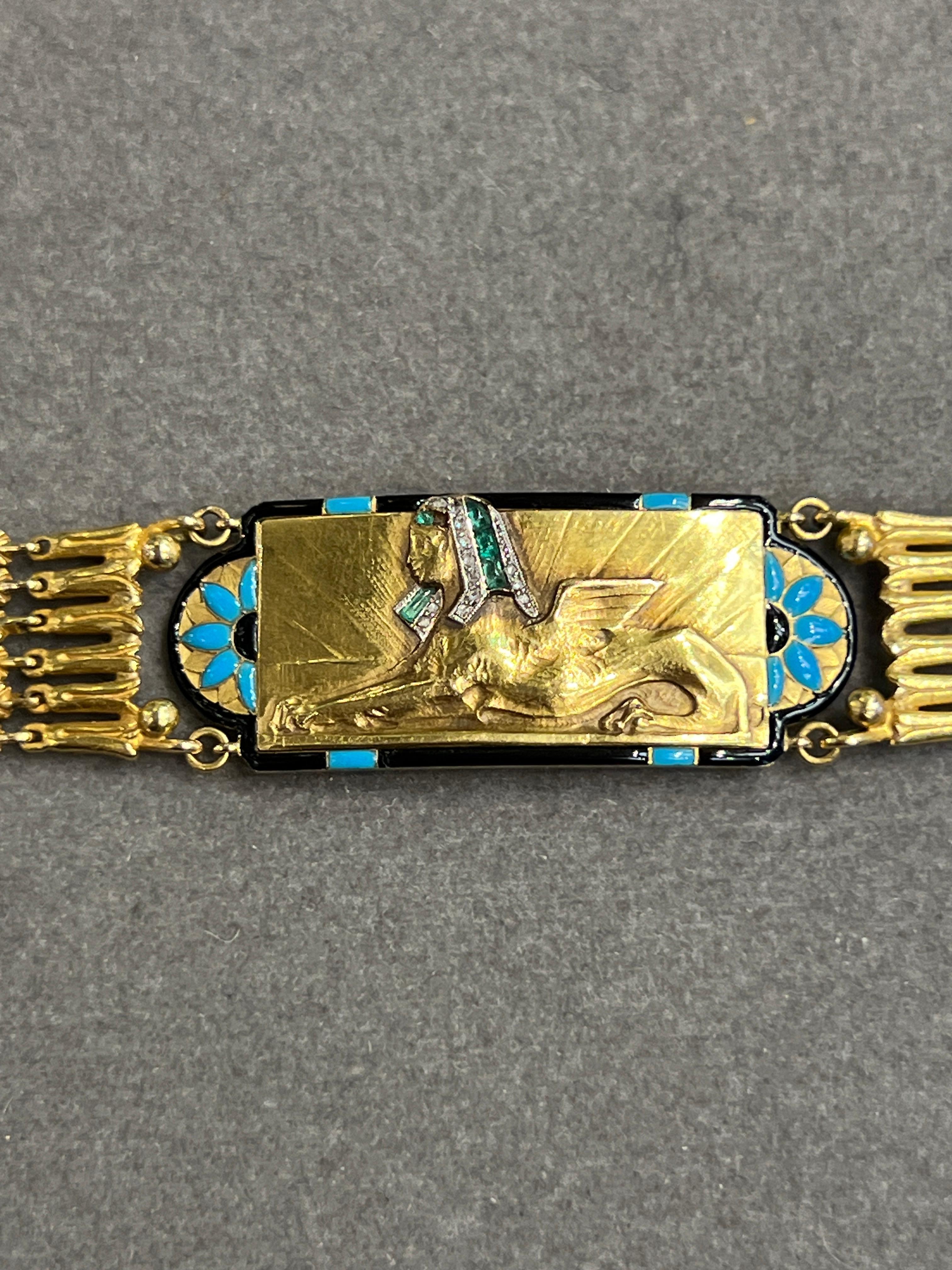 Cartier Egyptian Revival Bracelet 

A very rare yellow gold Cartier bracelet showcasing a winged sphinx adorned with cabochon emeralds, diamonds, turquoise, and black enamel.

Signed: Cartier and Numbered 
Circa 1920s

Accompanied with certificate