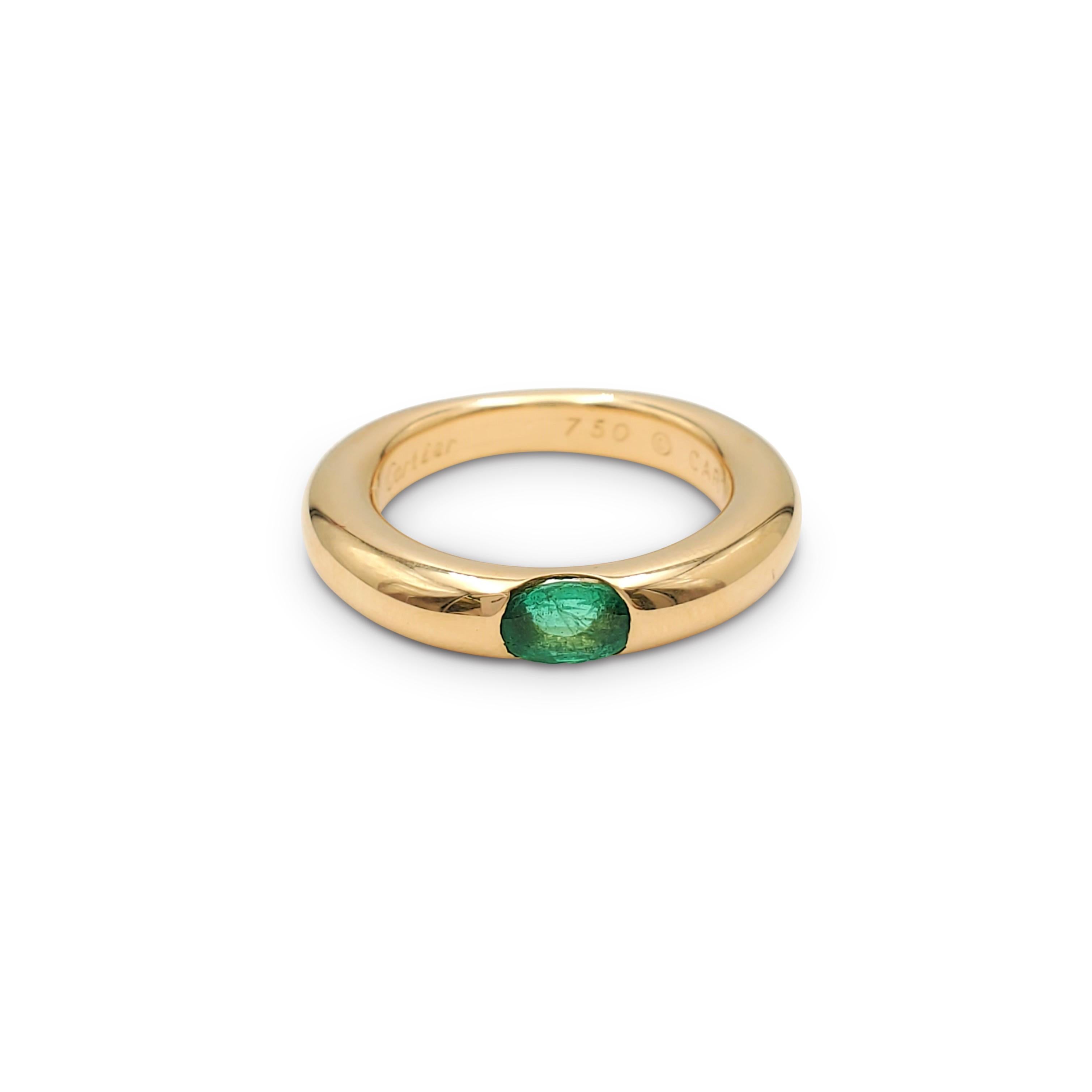 Authentic Cartier 'Ellipse' ring crafted in 18 karat yellow gold and set with one emerald stone weighing an estimated 0.35 carats total weight. Signed Cartier 1992, 750, 50, with serial number. The ring is presented with the original box and papers.