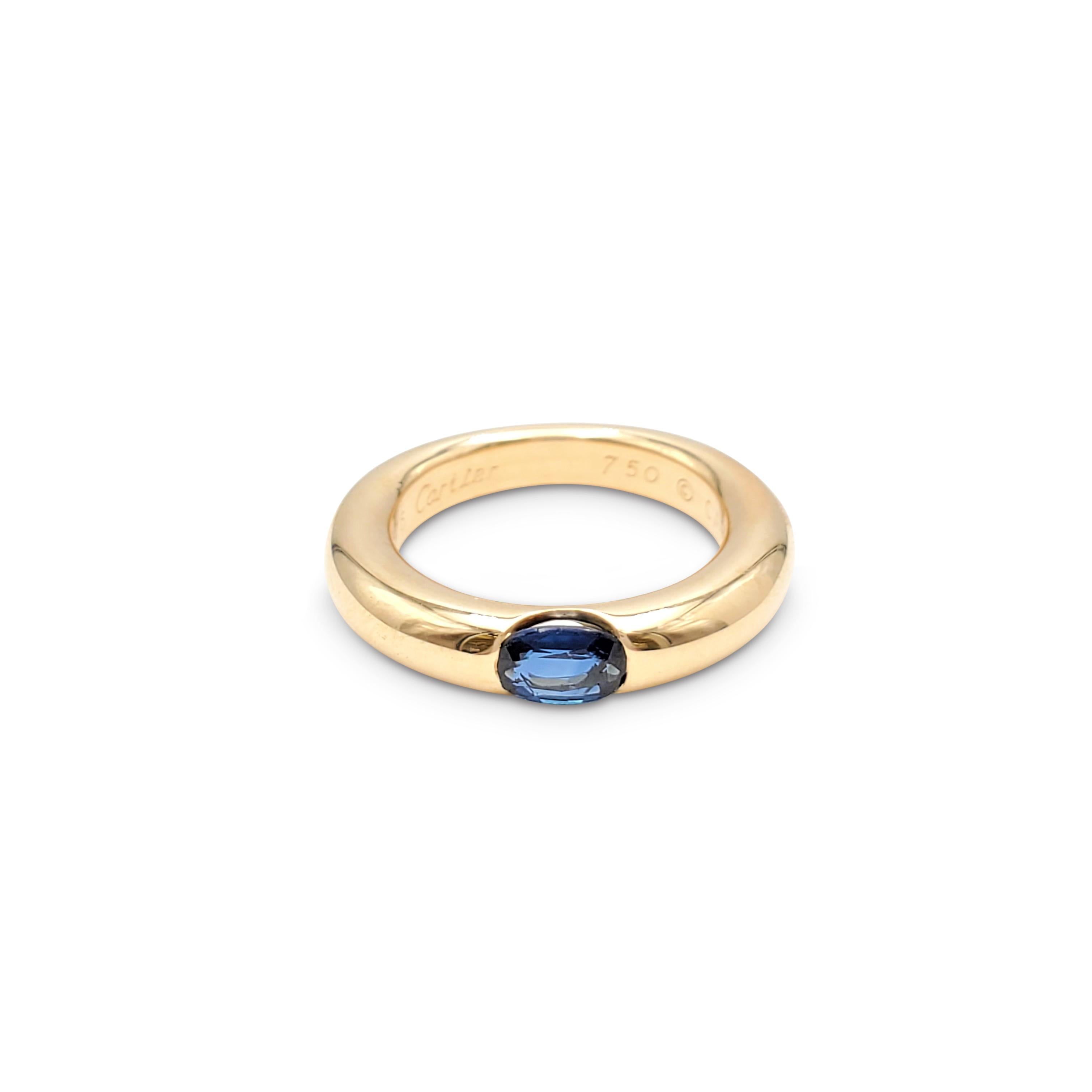 Authentic Cartier 'Ellipse' ring crafted in 18 karat yellow gold and set with one blue sapphire weighing an estimated 0.35 carats total weight. Signed Cartier 1992, 750, 49, with serial number. The ring is presented with the original papers, no box.