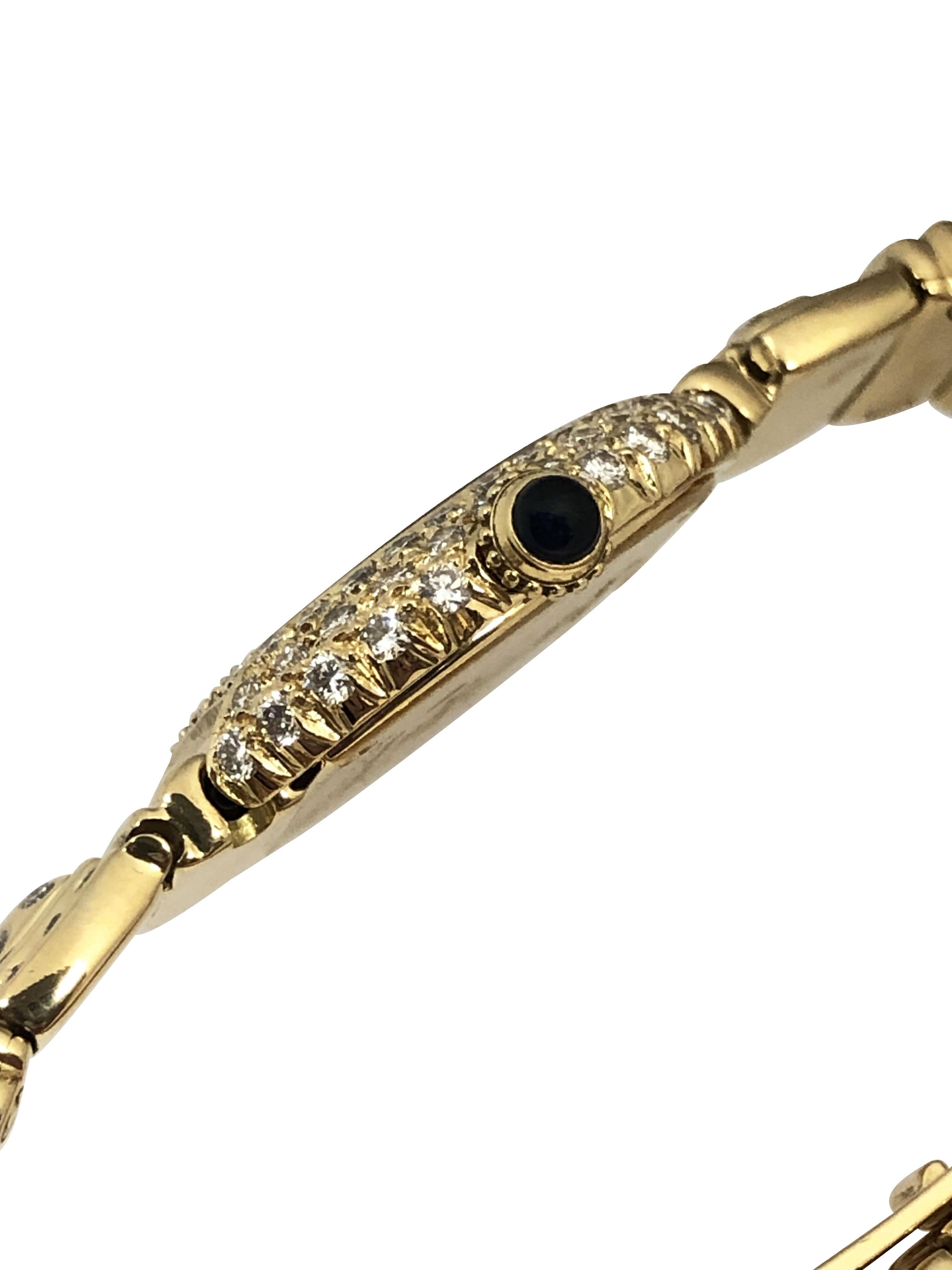 Circa 1990 Cartier Ellipse Ladies Wrist Watch,  25 x 22 M.M. 2 piece 18k Yellow Gold case set with Round Brilliant cut Diamonds and a Sapphire set crown, Quartz movement, off White dial with Black Roman numerals. 7/16 inch wide Ellipse bracelet set