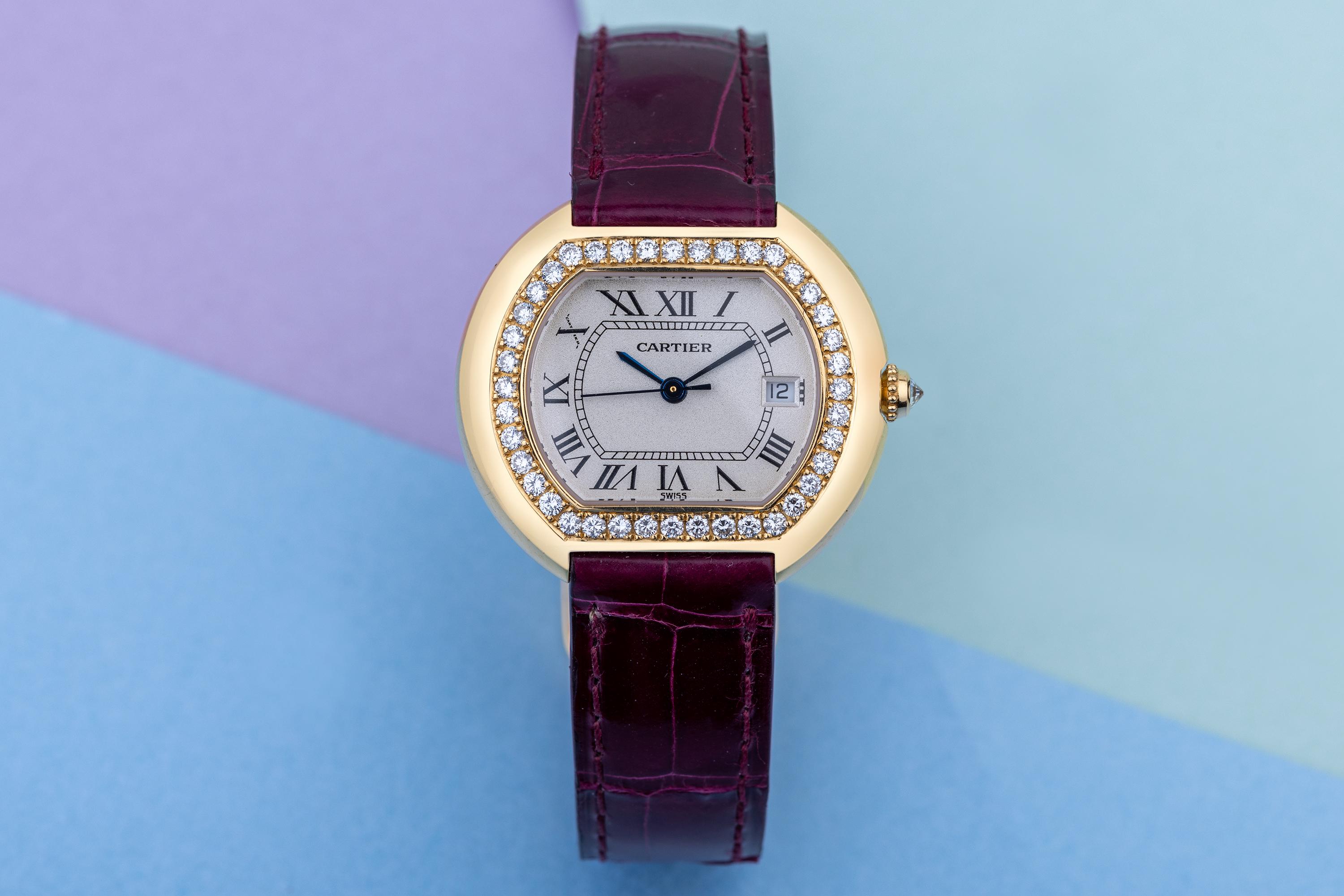 Pre-owned, excellent condition Cartier Ellipse reference 1481 18k Yellow Gold ladies wristwatch. Silver dial, Roman numeral hour markers, date display at 3 o'clock, an 18k Yellow Gold 32mm case, diamond bezel, winder with a diamond and deployant