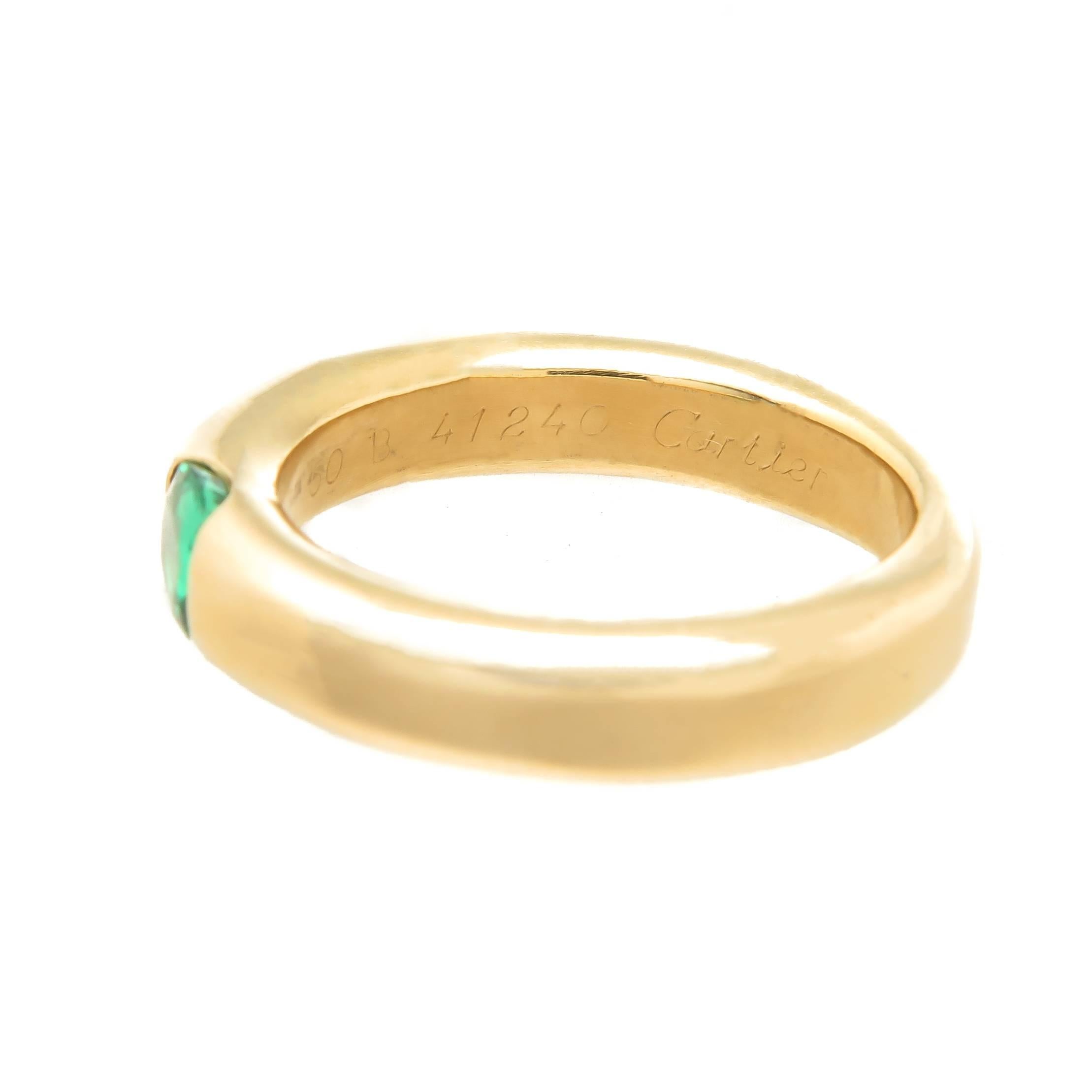 Circa 2000 Cartier Ellipse collection Stacking Band Ring, the 3.5 M.M. thick Ring is centrally set with a fine color Oval shape Emerald of approximately 1 carat. Finger size =  5 1/2. Excellent condition, fully signed and numbered.