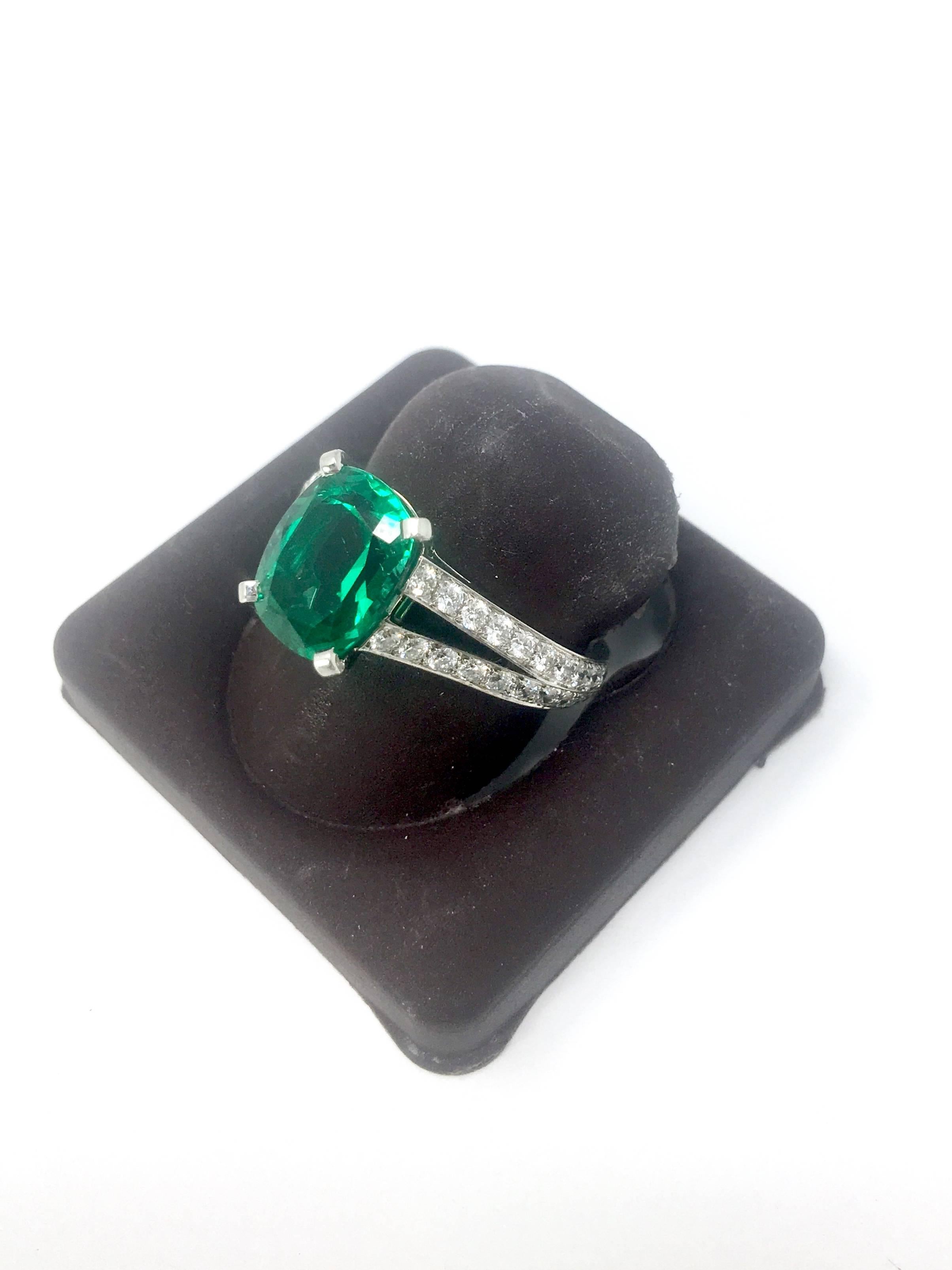 For sale is a lovely designer Cartier Diamond and Emerald Ring! 
The ring is crafted out of Platinum and comes with the Cartier box and papers.
The diamond mounting features forty-eight (48) Round Brilliant Cut diamonds, bead set in a split style