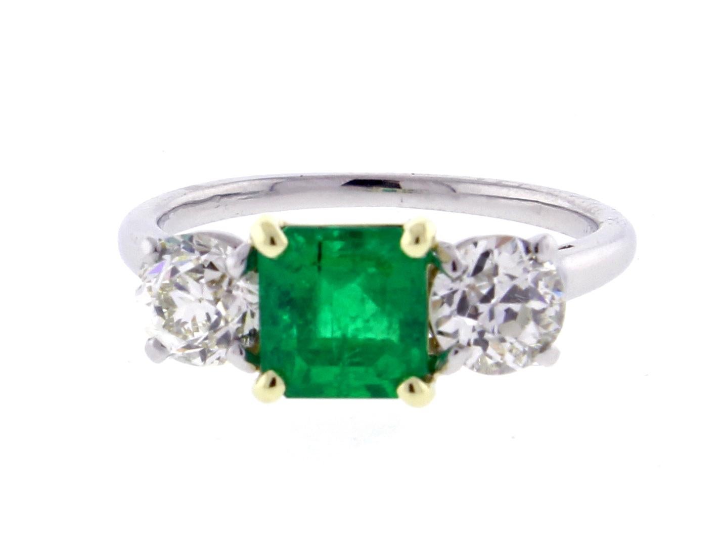 From Cartier, an Emerald and diamond three -stone ring. The center Emerald weighs 1.35 carats. The two side Old European cut diamonds weigh 1.35 carats total and are H color and VS clarity. The ring is platinum with the emerald set in 18 karat