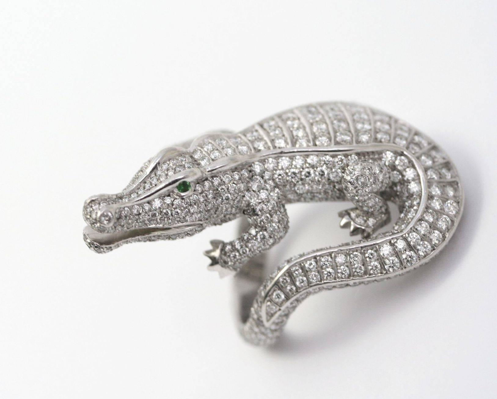 CARTIER Alligator Ring in platinum, round-cut diamonds (approximately 4,5 carats) and emerald eyes. 
1980-1990.
Signed and Numbered. 
Ring size 53 (French size). 6,5 (US size)
(39.15 grams)
Comes with a Cartier document 