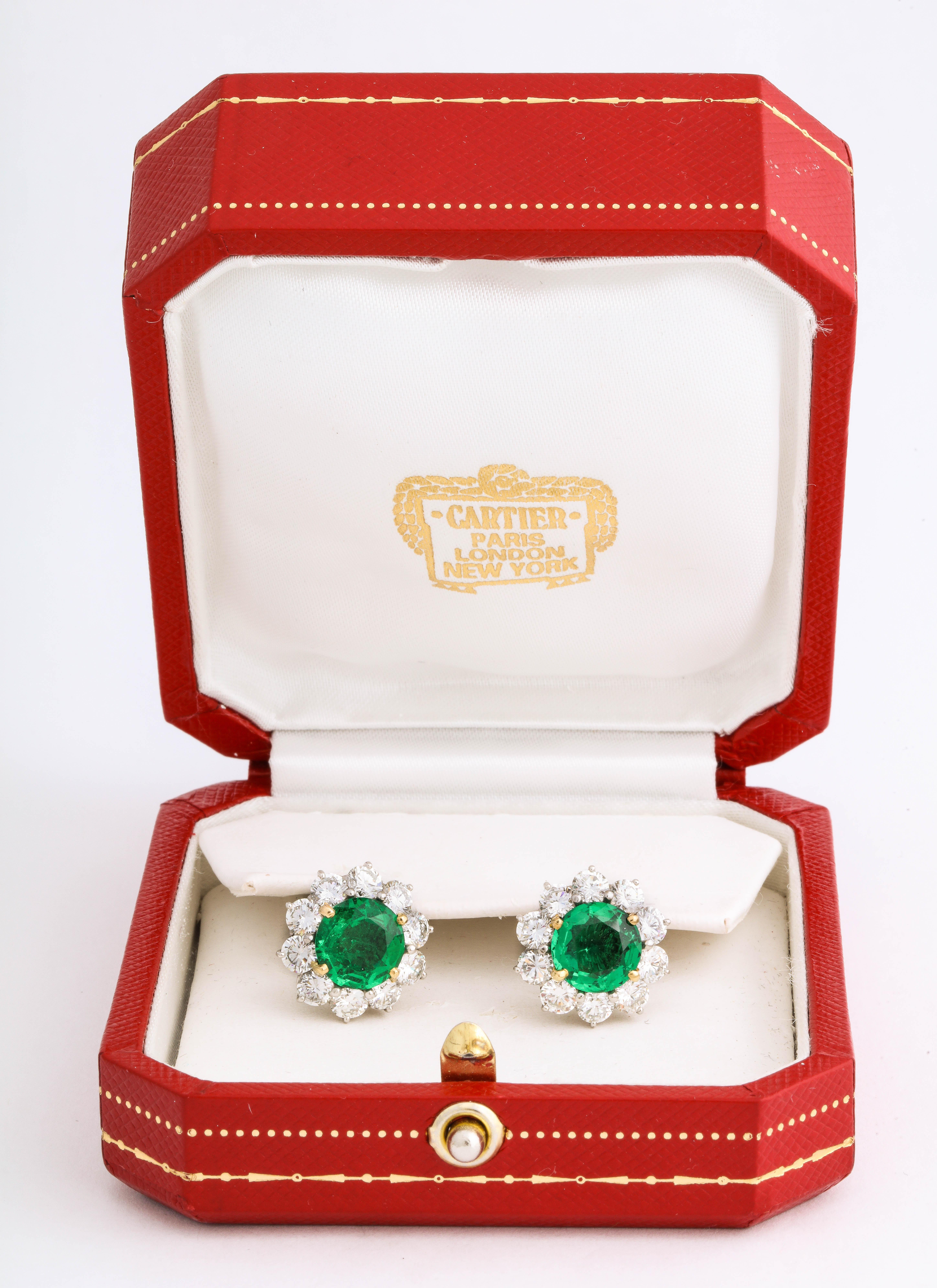 These elegant Emerald Diamond Platinum Clip and Post Earrings by Cartier feature two round emeralds measuring a total weight of 5.00 carats and 4.0 cts tw of fine white full cut diamonds, 

Materials: 
Platinum 6.5 dwt

Stones:
2 round emeralds @