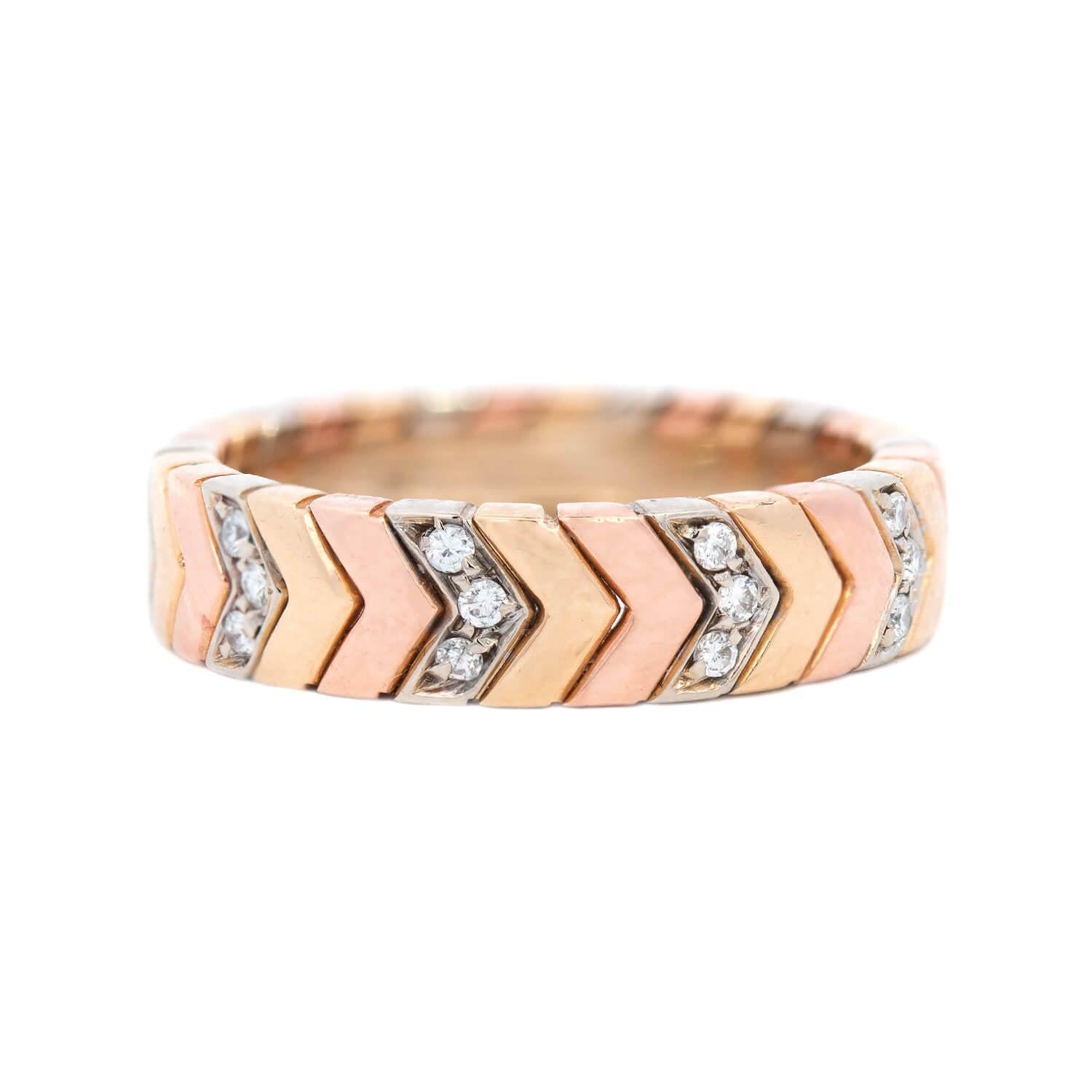 This fabulous estate ring is a signed piece by Cartier! Crafted in 18k mixed gold, the band is slightly wide and has an applied chevron motif in white, rose, and yellow gold. The mixed metals design carries around the entire ring, forming a seamless