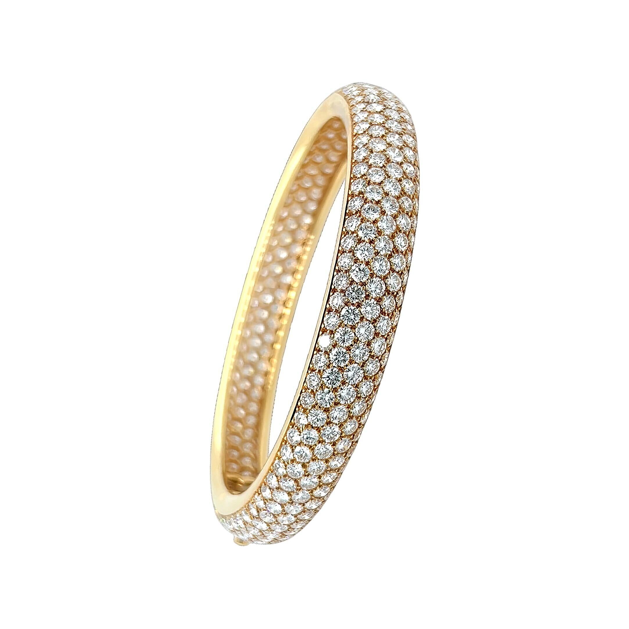 An 18 karat yellow gold and diamond bracelet, Cartier.  The Etincelle bracelet designed as a hinged oval convex bangle pave set all over with approximately 370 round brilliant cut diamonds.  Total diamond weight approximately 23.29 carats.  Inner