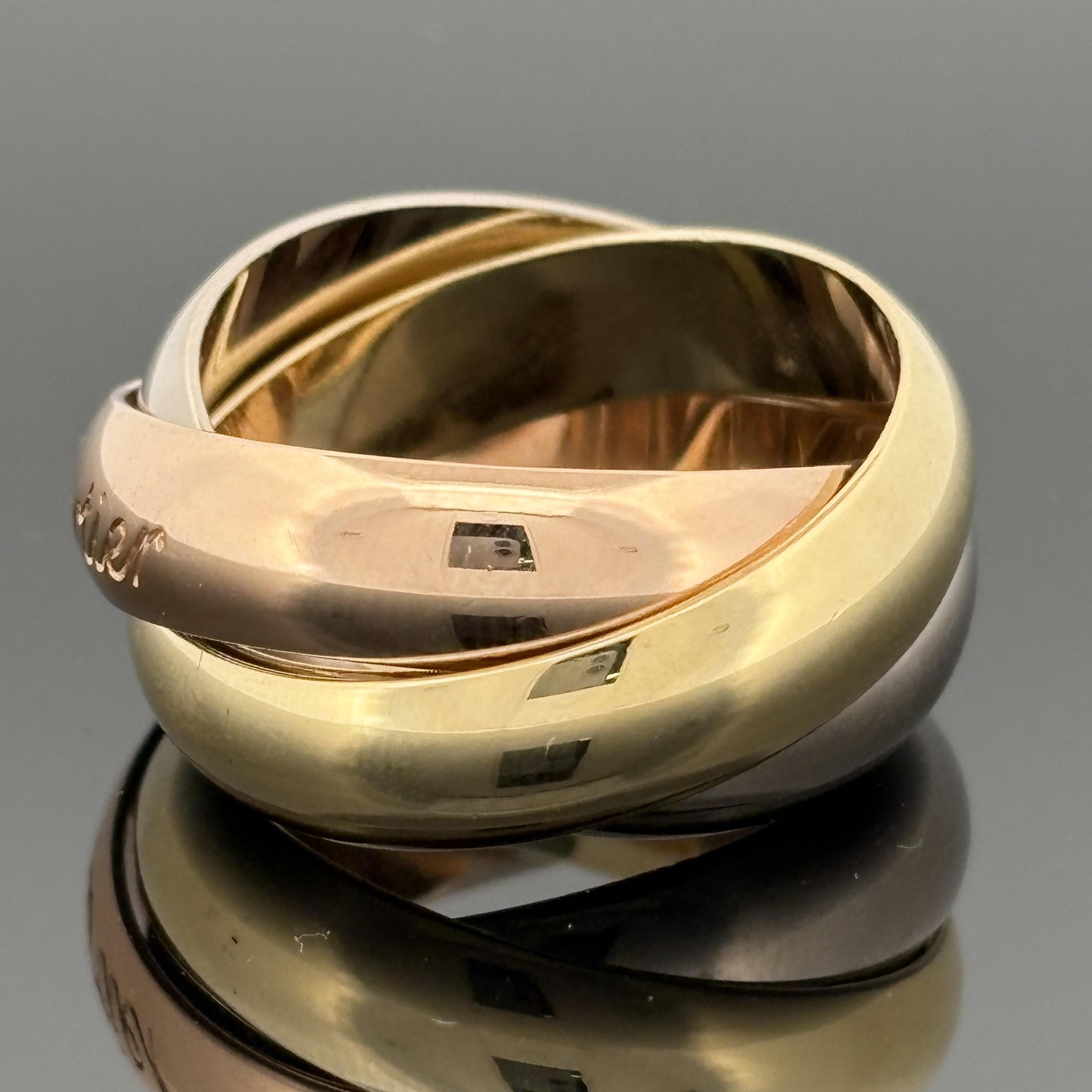 Un design iconico di Cartier, questo anello Trinity de Cartier è il modello extra large, realizzato in oro giallo, bianco e rosa 18 carati. Ciascuna fascia misura poco più di 5 mm di larghezza, per un totale di 10 mm sul dito. Le tre fasce