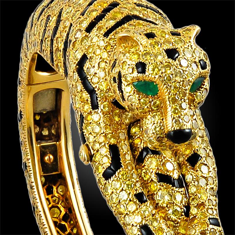 An extraordinary piece embodying one of Cartier’s most striking creatures, the tiger, designed as a hinged bangle, pave-set with a myriad of round-cut fancy yellow diamonds of exceptional brilliance, adorned throughout with calibre black onyx-set