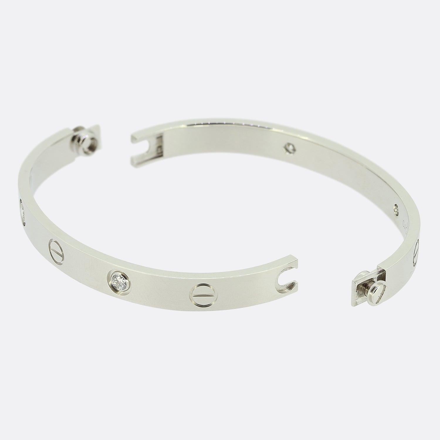 Voici un bracelet en or blanc 18 ct de la maison de joaillerie de luxe de renommée mondiale Cartier. Ce bracelet fait partie de la collection LOVE et présente quatre diamants ronds de taille brillant à côté du motif iconique de la vis. 

