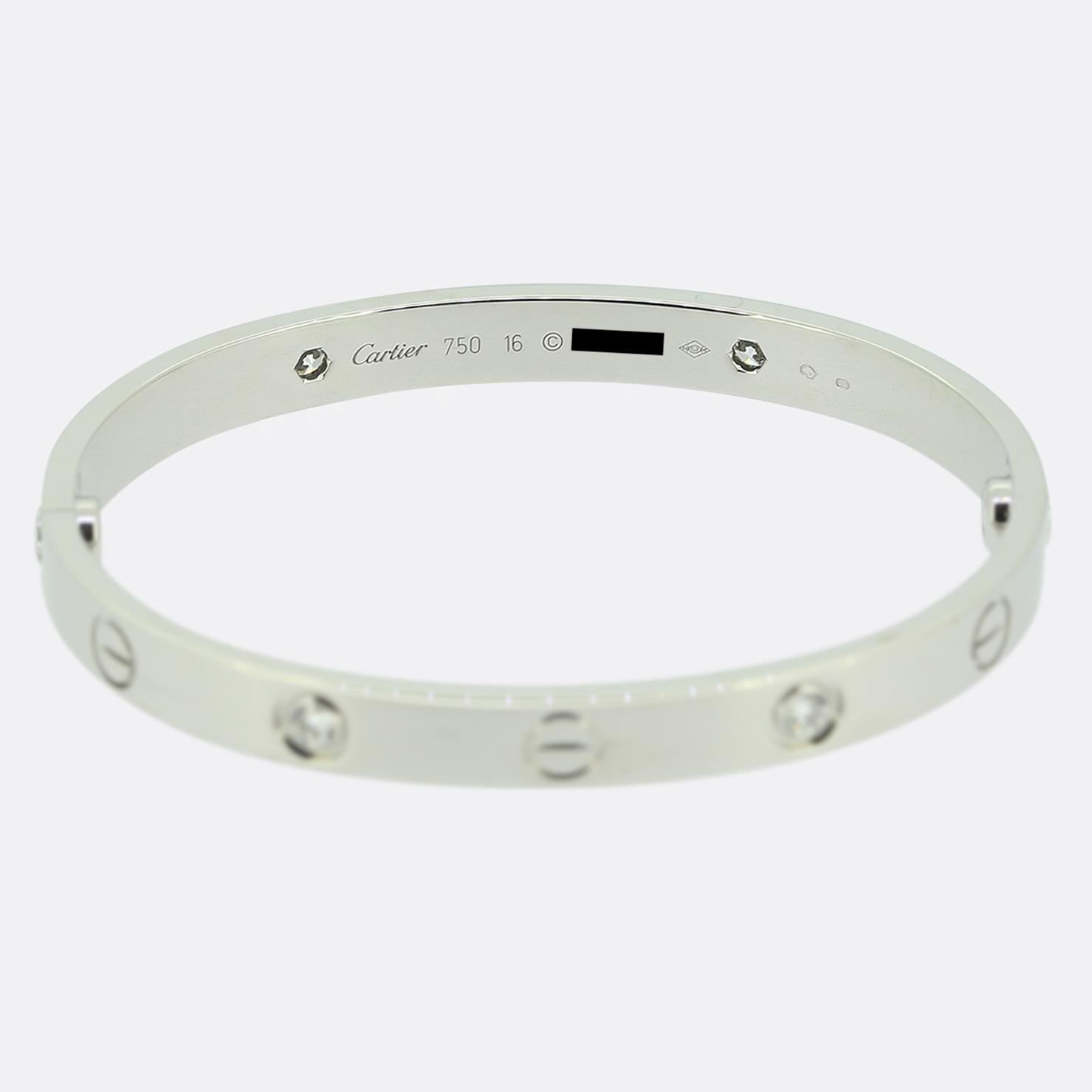 Aquí tenemos un brazalete de oro blanco de 18 ct de la mundialmente conocida casa de joyas de lujo Cartier. Este brazalete forma parte de la colección LOVE y presenta cuatro diamantes redondos de talla brillante junto al icónico motivo del