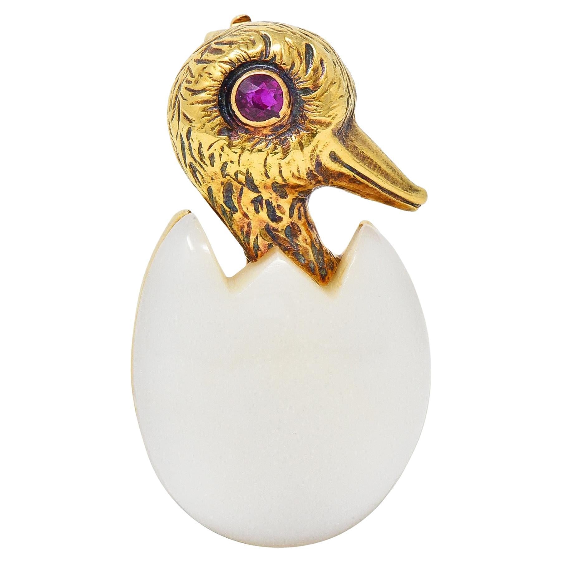 Cartier France, broche oiseau attachant en or jaune 18 carats, calcédoine et rubis, années 1960 en vente