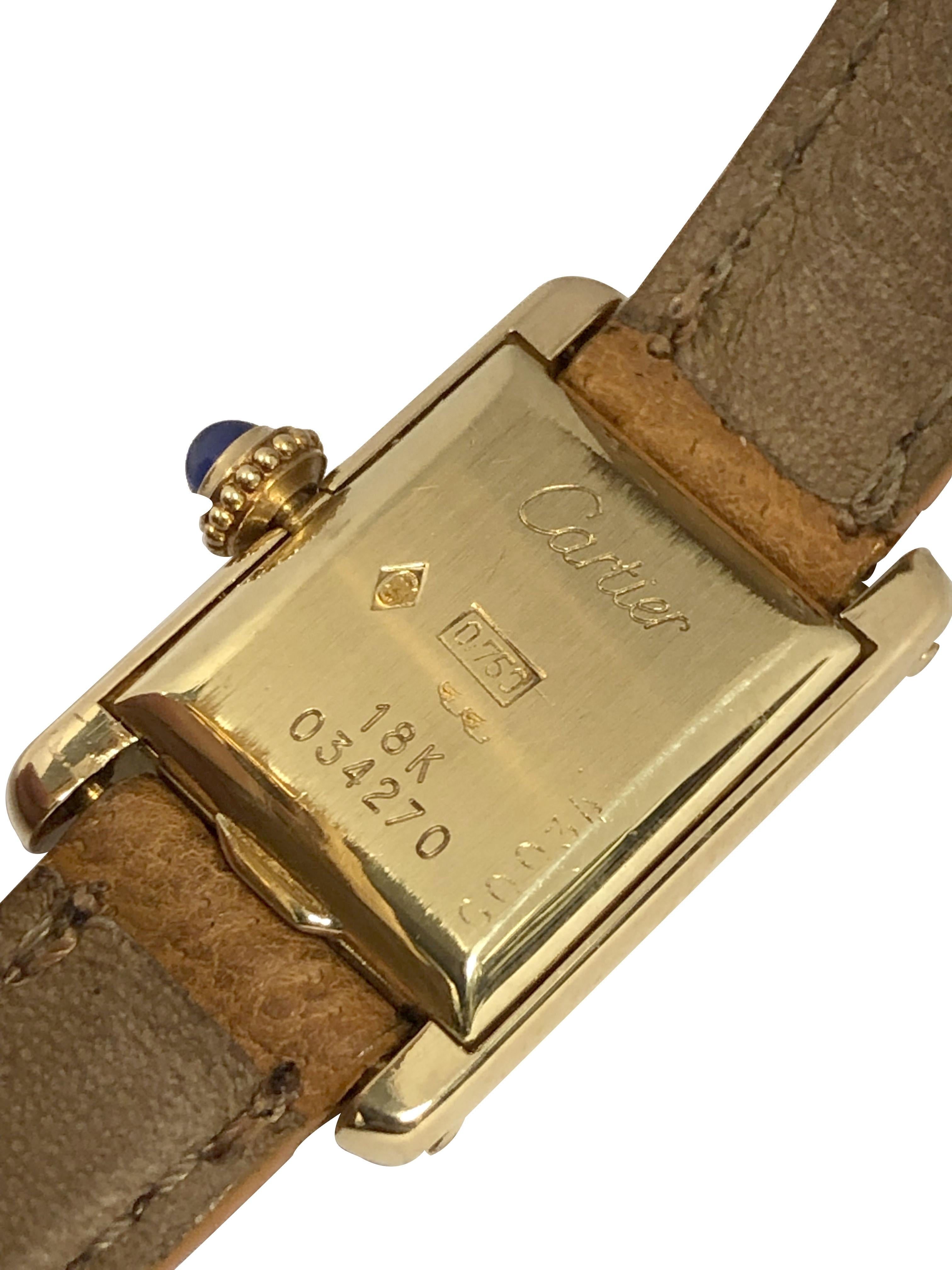 Circa 1970s Scarce and Hard to Find Mini Tank Wrist Watch, 23 x 15 M.M. (  lugs included in length ) 2 piece 18k Yellow Gold Case. Cartier Inc. Mechanical, Manual wind Nickle lever movement, Sapphire set crown. 10 M.M wide Cartier Tan Leather Strap