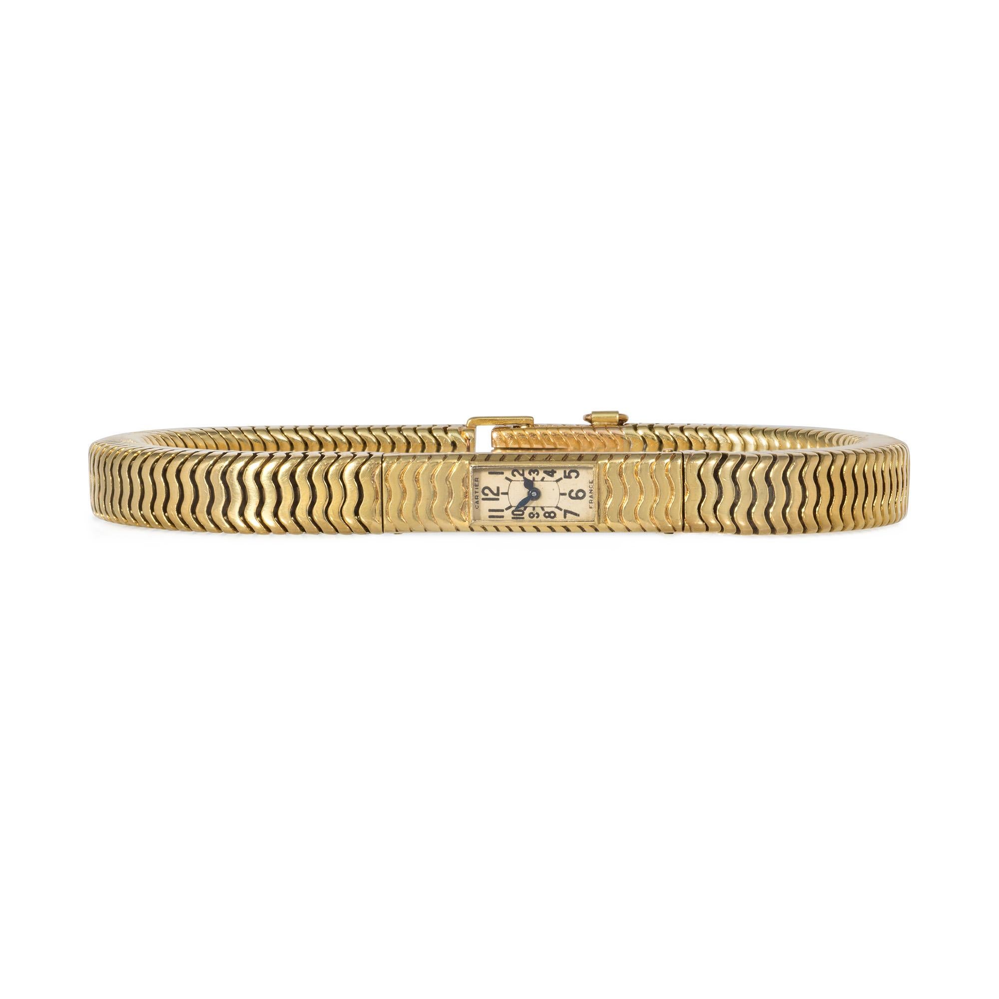 A Retro gold backwinder watch bracelet of box snake link design featuring a rectangular face with Arabic numerals, completed by a foldover clasp, in 18k. Cartier, France. With a Cartier watch box.

Watch dimensions: 6 1/2