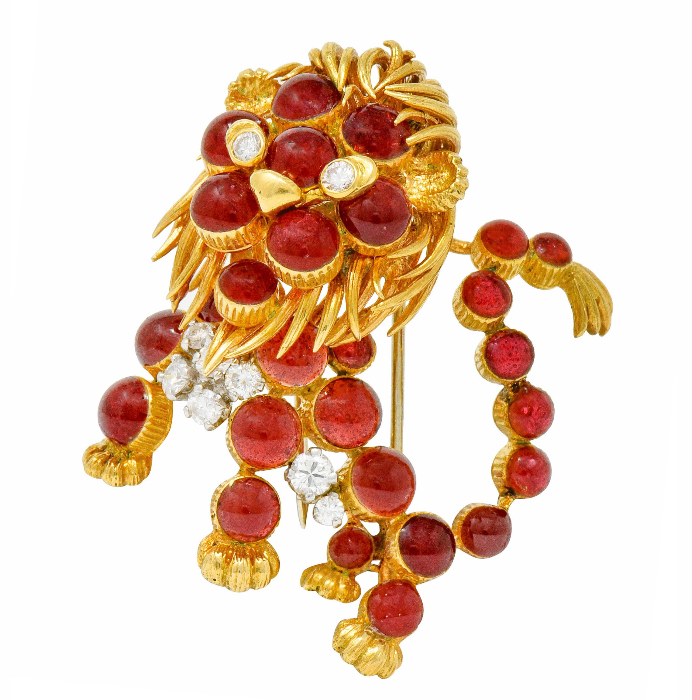 Designed as a whimsical lion with a stylized textured gold mane and other features

Body is comprised of round glass cabochon, bezel set and brick red in color, measuring 4.0 mm to 3.0 mm

With round brilliant diamond accented chest and eyes,
