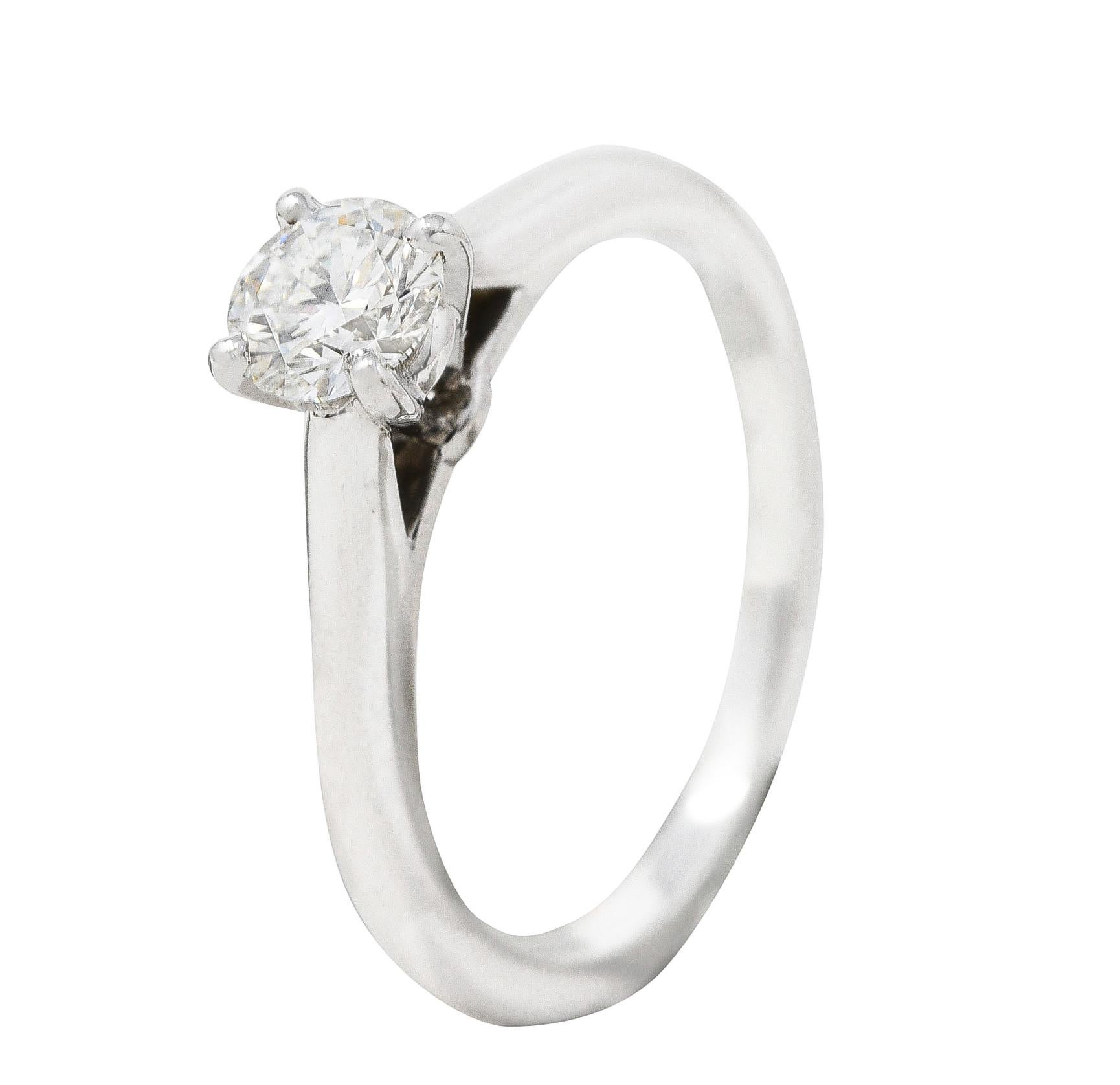 Centering a round brilliant cut diamond weighing 0.38 carat total - G color with VVS2 clarity. Prong set in a sleek basket and flanked by cathedral shoulders. Completed by high polished finish. Stamped for platinum and inscribed with carat weight.