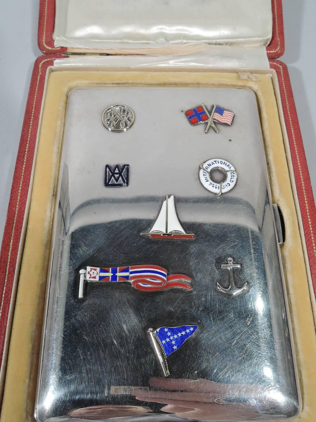 Art Deco 950 silver and enamel cigarette case. Retailed by Cartier in France. Rectangular and hinged. On cover are enameled nautical and national symbols including a sailboat, lifesaver American and Norwegian flags, and pennant. This case presented