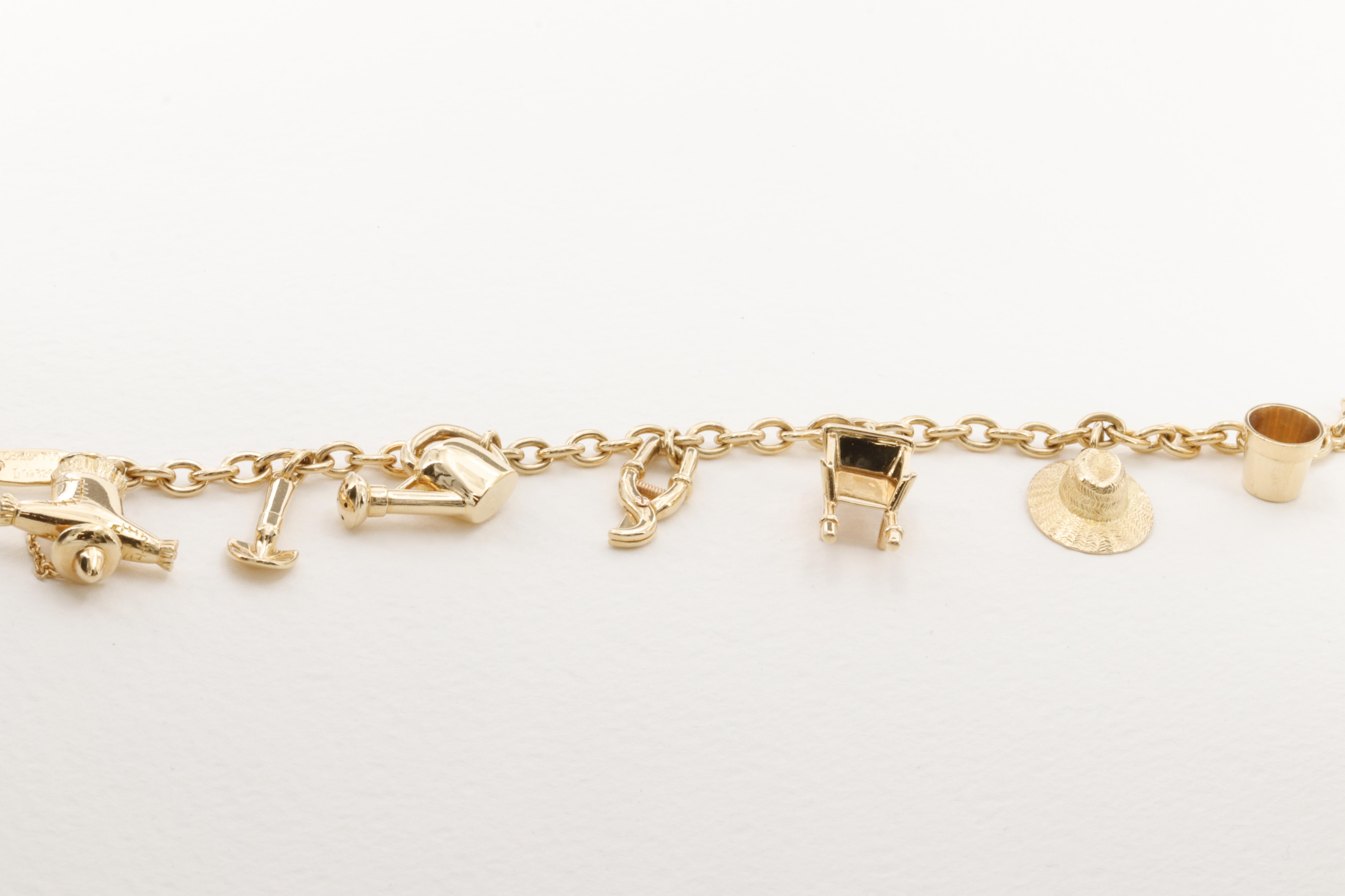 An incredible Cartier 18 karat yellow gold themed charm bracelet featuring 7 gardening inspired charms, from a whimsical scarecrow to a miniature shovel, the 3 dimensional charms are very representative of their real life counterparts. 

The