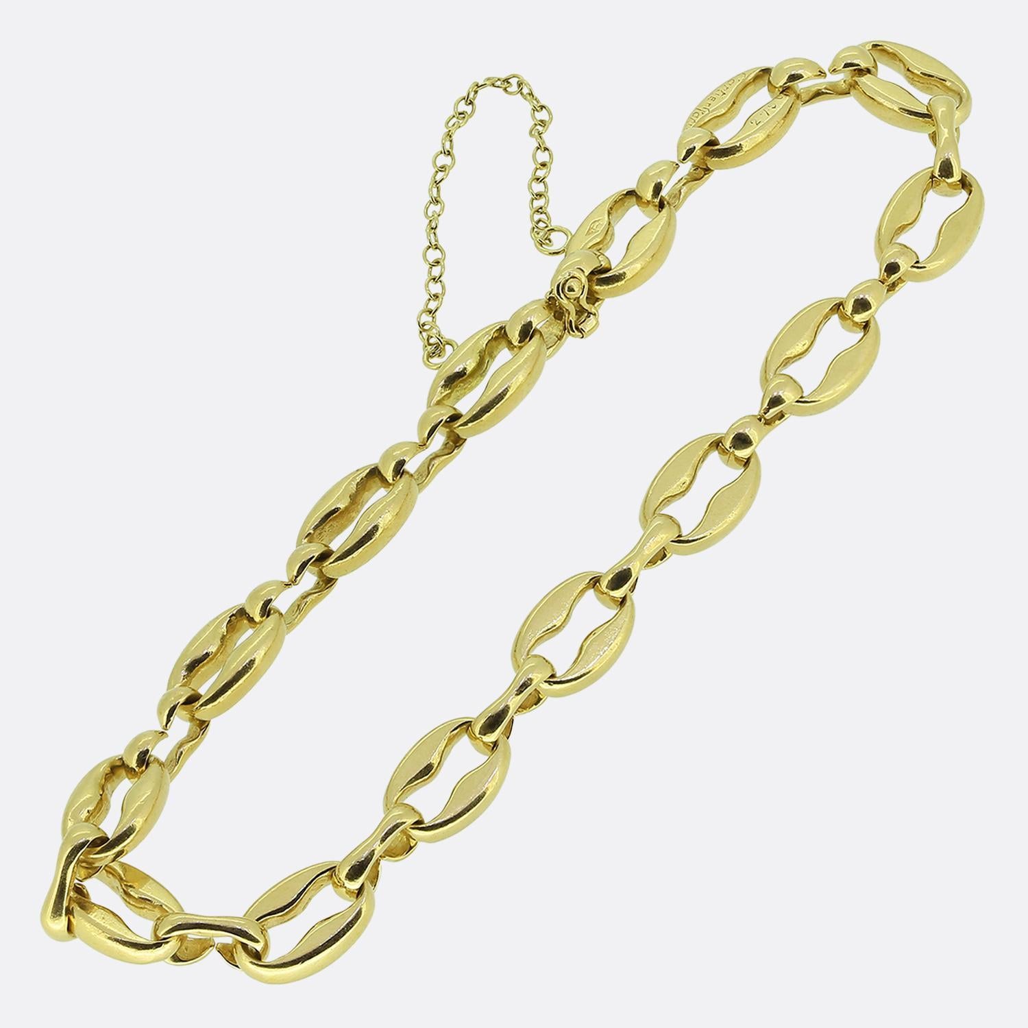 Ecco un bracciale a catena in oro giallo 18ct di Georges Lenfant per la famosa casa di gioielli di lusso Cartier. Questo braccialetto presenta una serie di maglie ovali intrecciate, ognuna con una finitura liscia e non abbellita. Il design è audace