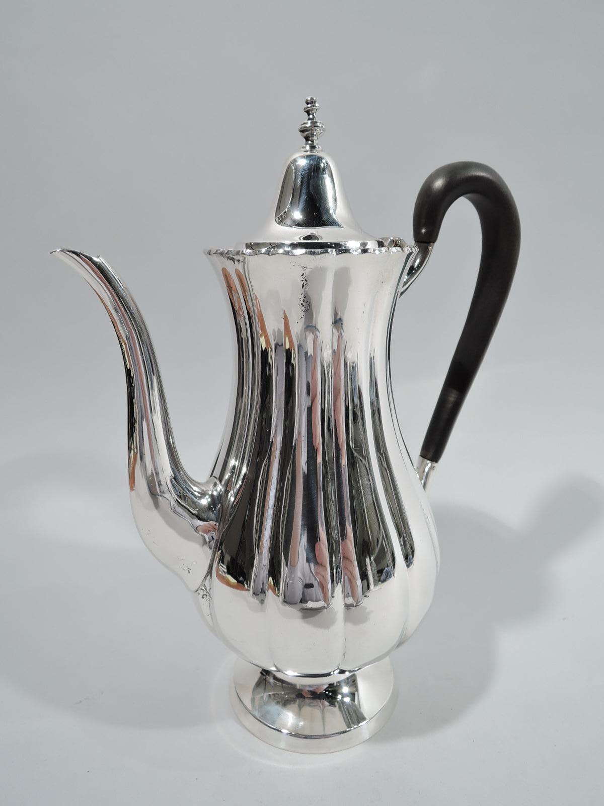 Georgian-style sterling silver coffeepot. Retailed by Cartier in New York. Lobed baluster body, hinged and domed cover with vasiform finial, high looping stained-wood handle, s-scroll spout, and raised and round foot. Fully marked including no. 80,