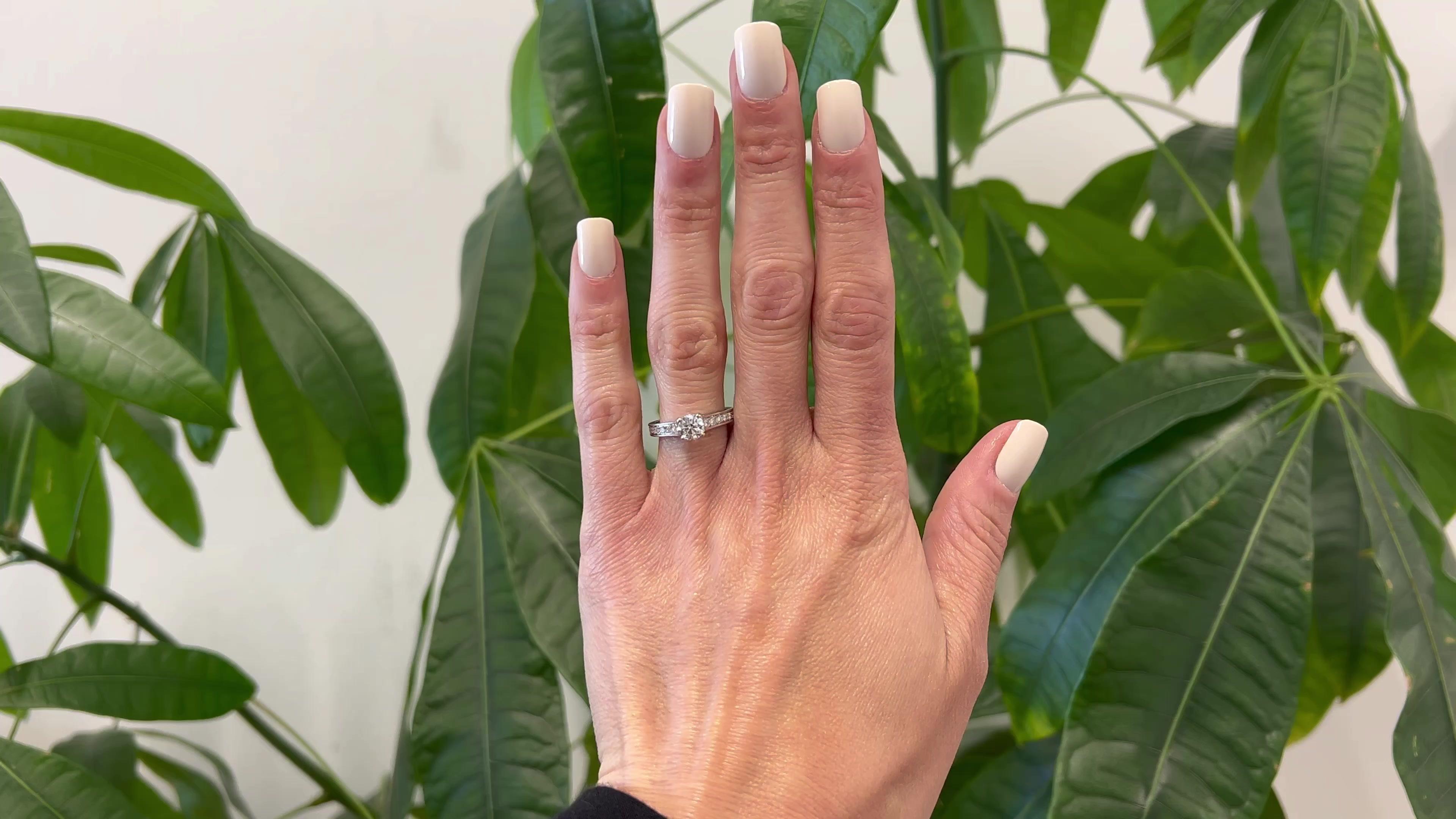 One Cartier GIA 0.71 Carat Round Brilliant Cut Diamond Platinum Ring. Featuring one GIA round brilliant cut diamond of 0.71 carat, accompanied with GIA #2147146014 stating the diamond is E color, VVS1 clarity. Accented by 18 round brilliant cut