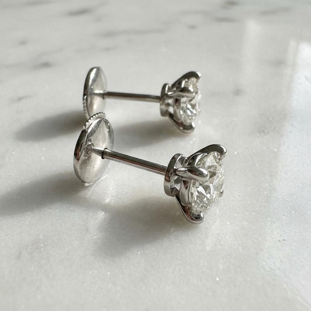 Estos elegantes pendientes de diamantes Cartier presentan dos excepcionales diamantes brillantes redondos naturales certificados por el GIA con un peso total en quilates combinado de 2 quilates. Cada diamante se talla con maestría según los