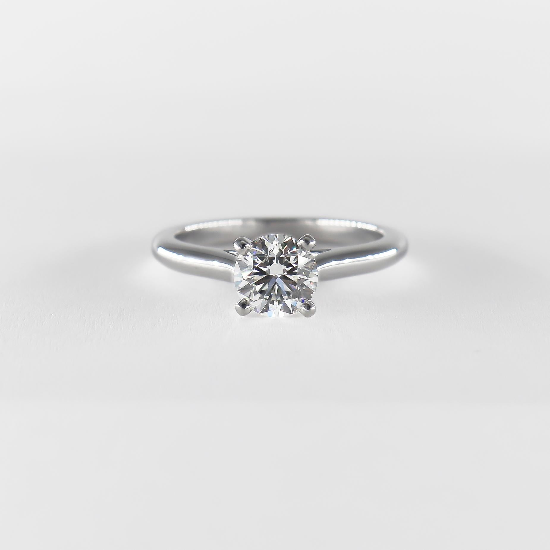 An elegant piece from the house of Cartier, this timeless engagement ring exemplifies Cartier's sophistication and quality. This sleek platinum solitaire features a stunning 1.32 carat round diamond, certified by GIA to be G color and VS1 clarity.