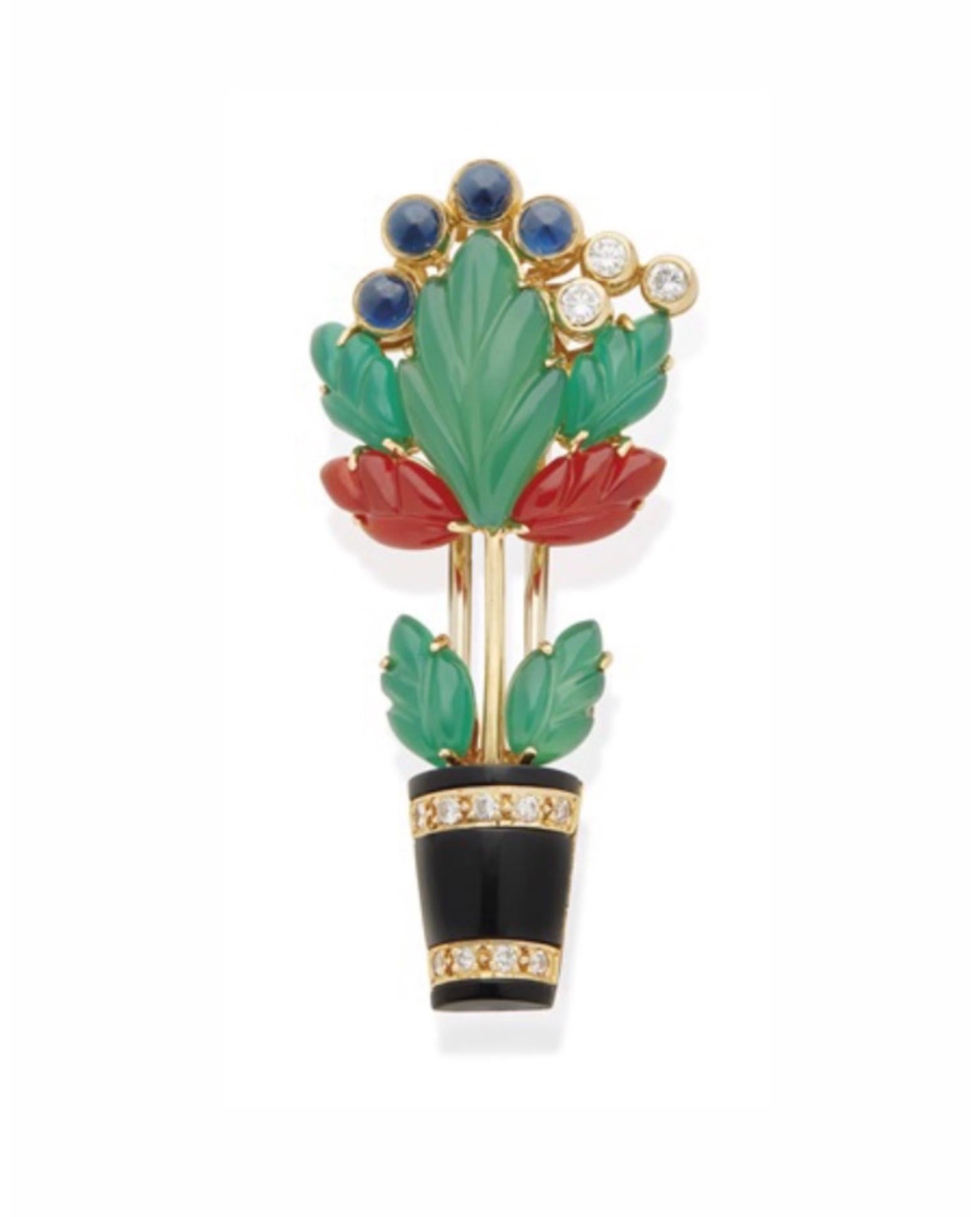 Cartier flowering vase brooch in 18kt yellow gold with onyx, dyed green chalcedony and carnelian, cabochon sapphires and brilliant-cut diamonds. Circa 1989.
Measures 4.4 x 2 cm. (1.7 x 0.8 in.)