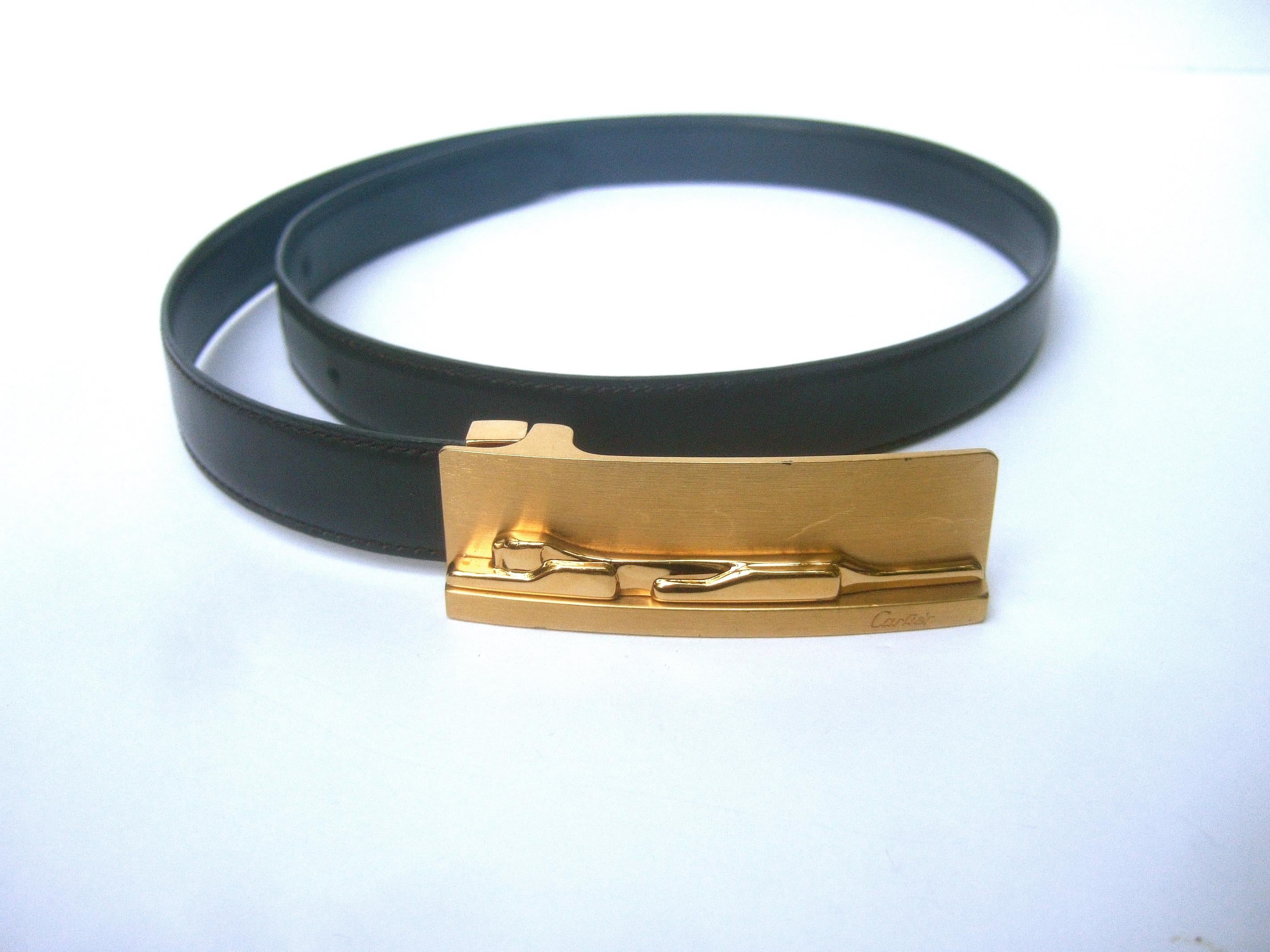 Cartier gilt metal panther buckle reversible women's belt c 1990s
The elegant belt is designed with a sleek panther figure on the gold metal buckle
The stylized panther is sheathed in shiny polished gold metal. In contrast the elongated rectangular