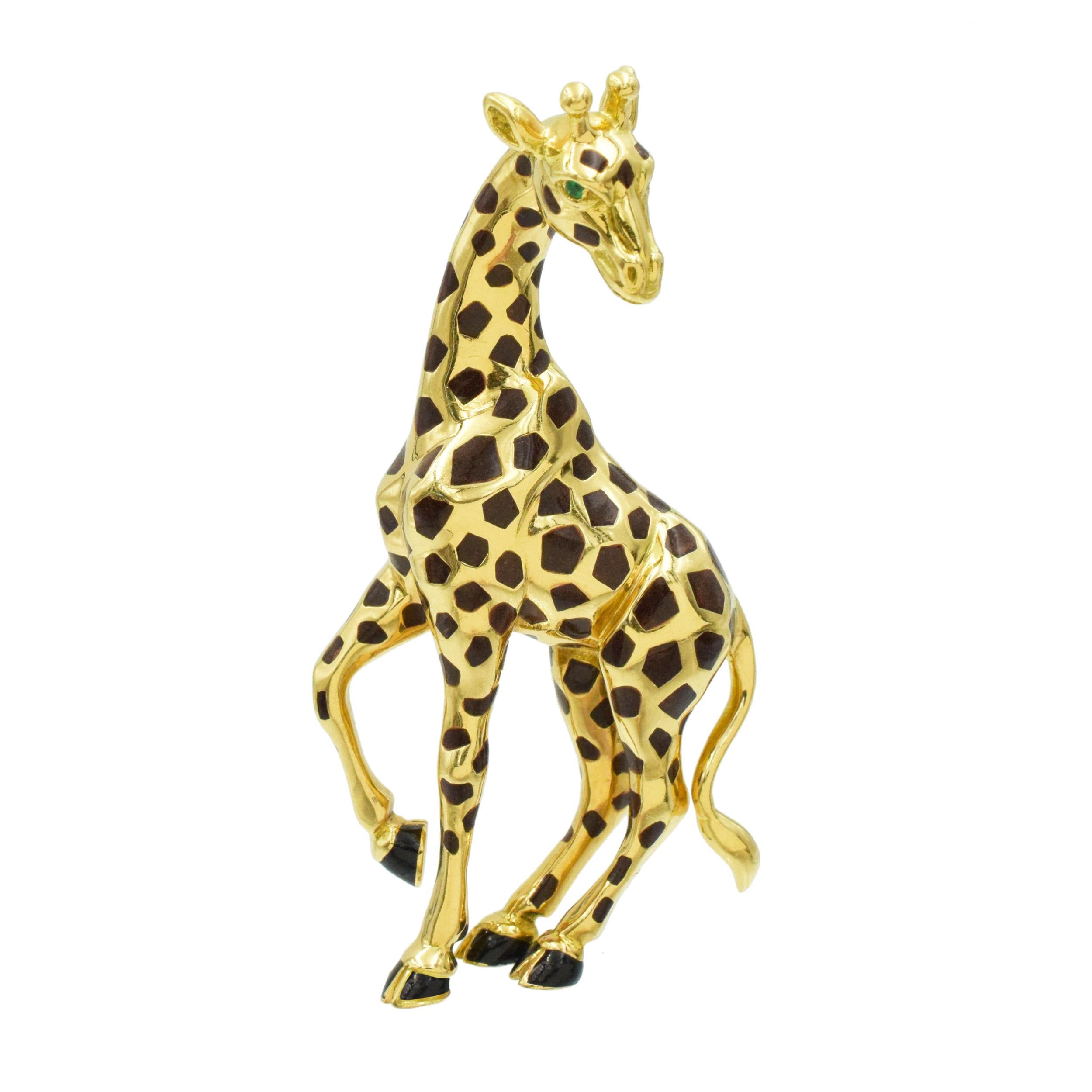 Broche Girafe de Cartier en or jaune 18k, décorée d'émeraudes et d'émail. 
La girafe est émaillée de taches brunes en émail translucide et de sabots en émail noir. Les deux yeux sont sertis d'une émeraude ronde facettée. Équipé d'une double goupille