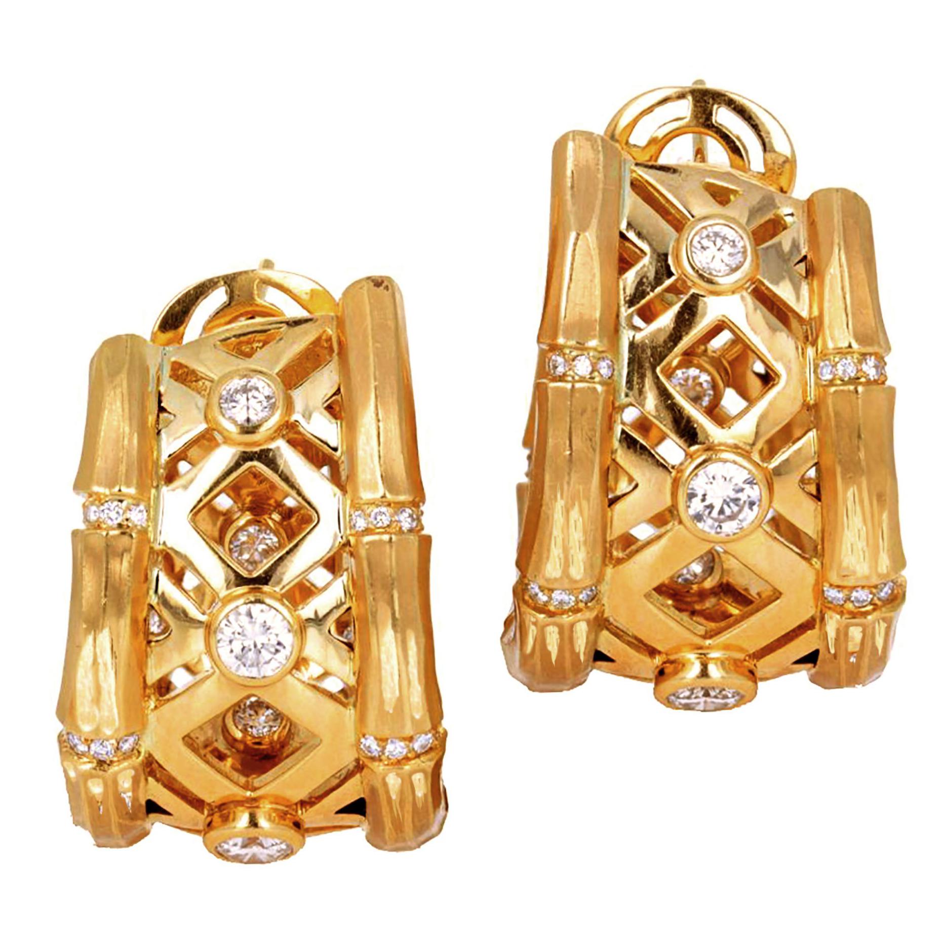 This pair of classic bamboo hoop earrings features bezel set round brilliant diamonds weighing approximately 1.45 carats total. The 18 karat yellow gold is brushed and the bamboo links connect by rows of smaller brilliant round diamonds. The are