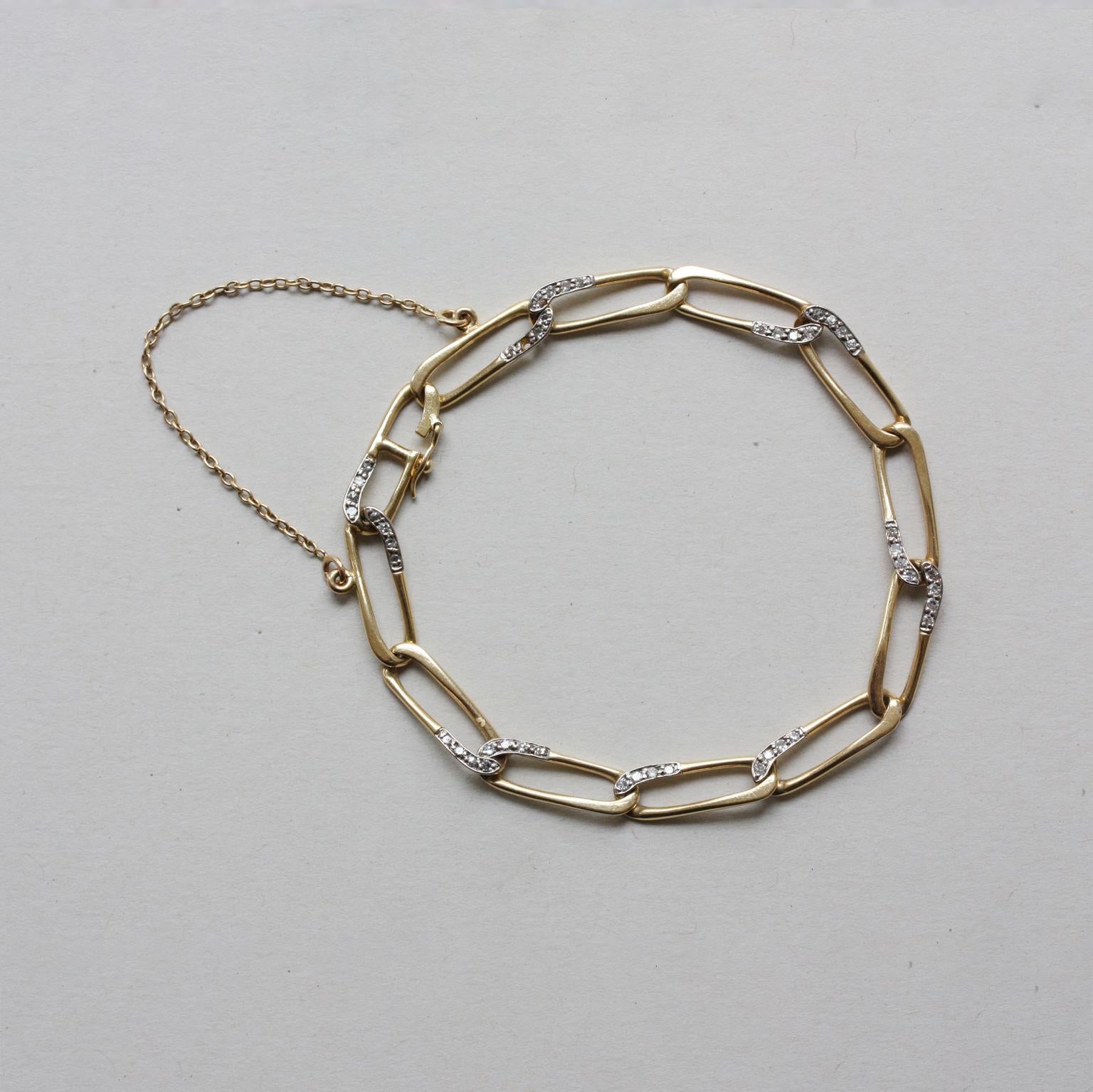 An 18 carat gold and diamond paperclip link bracelet (with safety chain), Signed and numbered: Cartier, 113598.

weight: 12.33 grams
dimensions: 19.5 x 0.6 cm